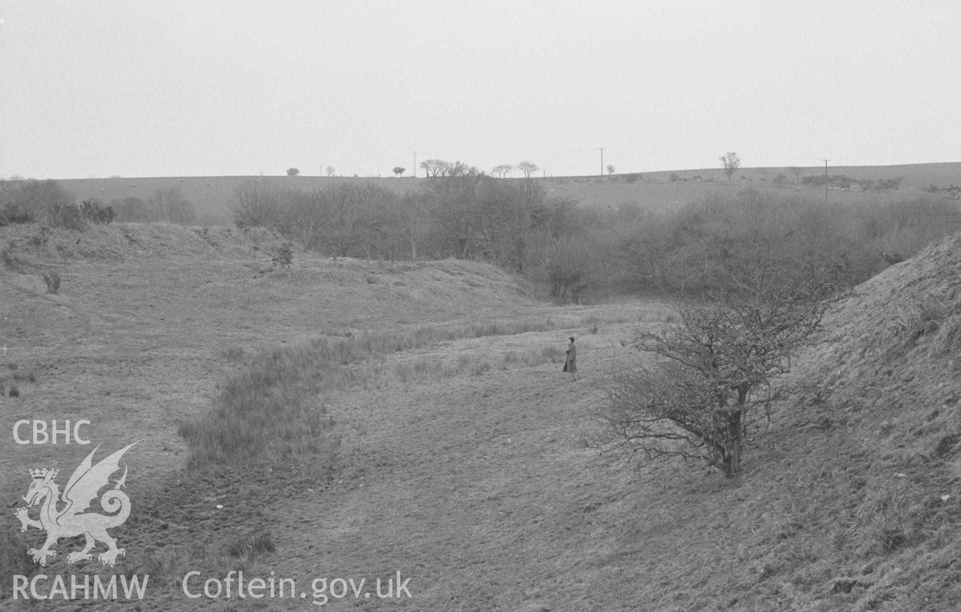 Digital copy of a black and white negative showing Cwm Castell, Mydriolyn, south east of New Quay. Photographed in April 1964 by Arthur O. Chater from Grid Reference SN 4692 5534, looking north-south east. Panorama, 1 of 3 photos.