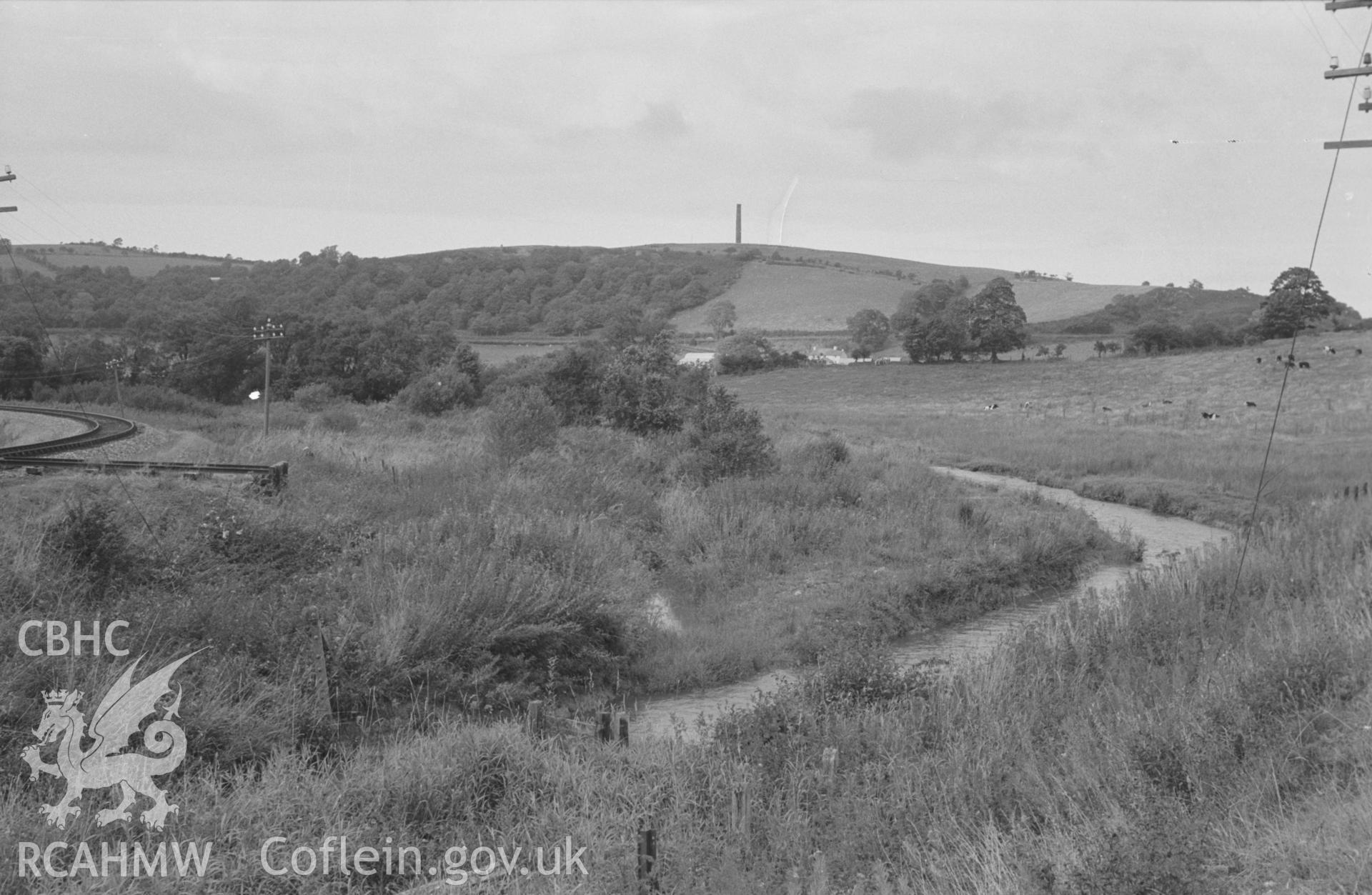 Digital copy of black and white negative showing the Lampeter, Aberayron & New Quay Light Railway near Silian, with the Afon Denys and Derry Ormond tower beyond. Photographed by Arthur O. Chater in September 1966 looking north north west from SN 588 504.