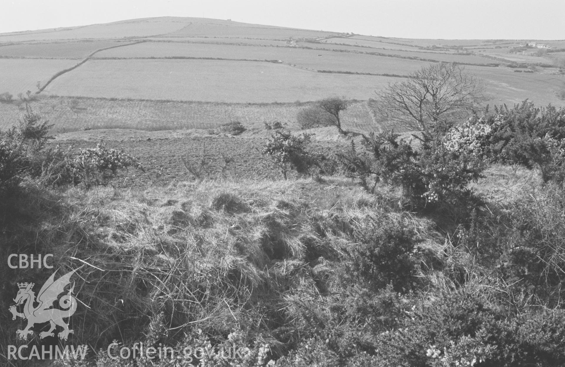 Digital copy of a black and white negative showing The Castell, looking across the east rampart to the north west corner of the camp; Penmoelciliau hill on left; Ciliau farm on extreme right. Photographed by Arthur O. Chater in April 1968. (Looking north west from Grid Reference SN 356 555).