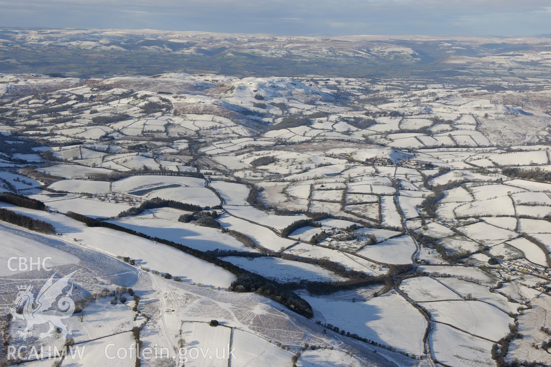 Graig yr Onnen earthwork, with Colwyn Castle, the Roman fort at Colwyn Castle and Fforest farm, Glascwm, beyond. Oblique aerial photograph taken during Royal Commission?s programme of archaeological aerial reconnaissance by Toby Driver, 15th January 2013.