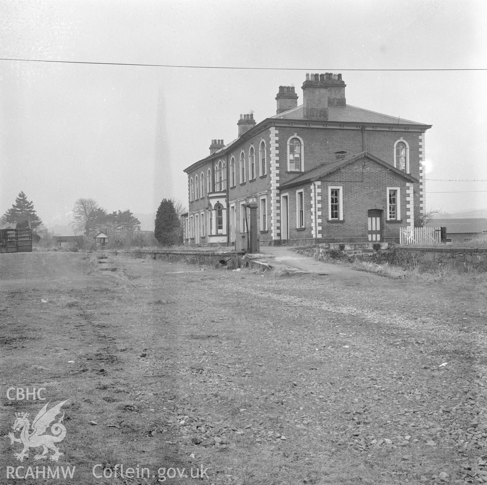 Digital copy of a black and white negative showing the front elevation of Llanidloes Railway Station, taken by Douglas Hague.