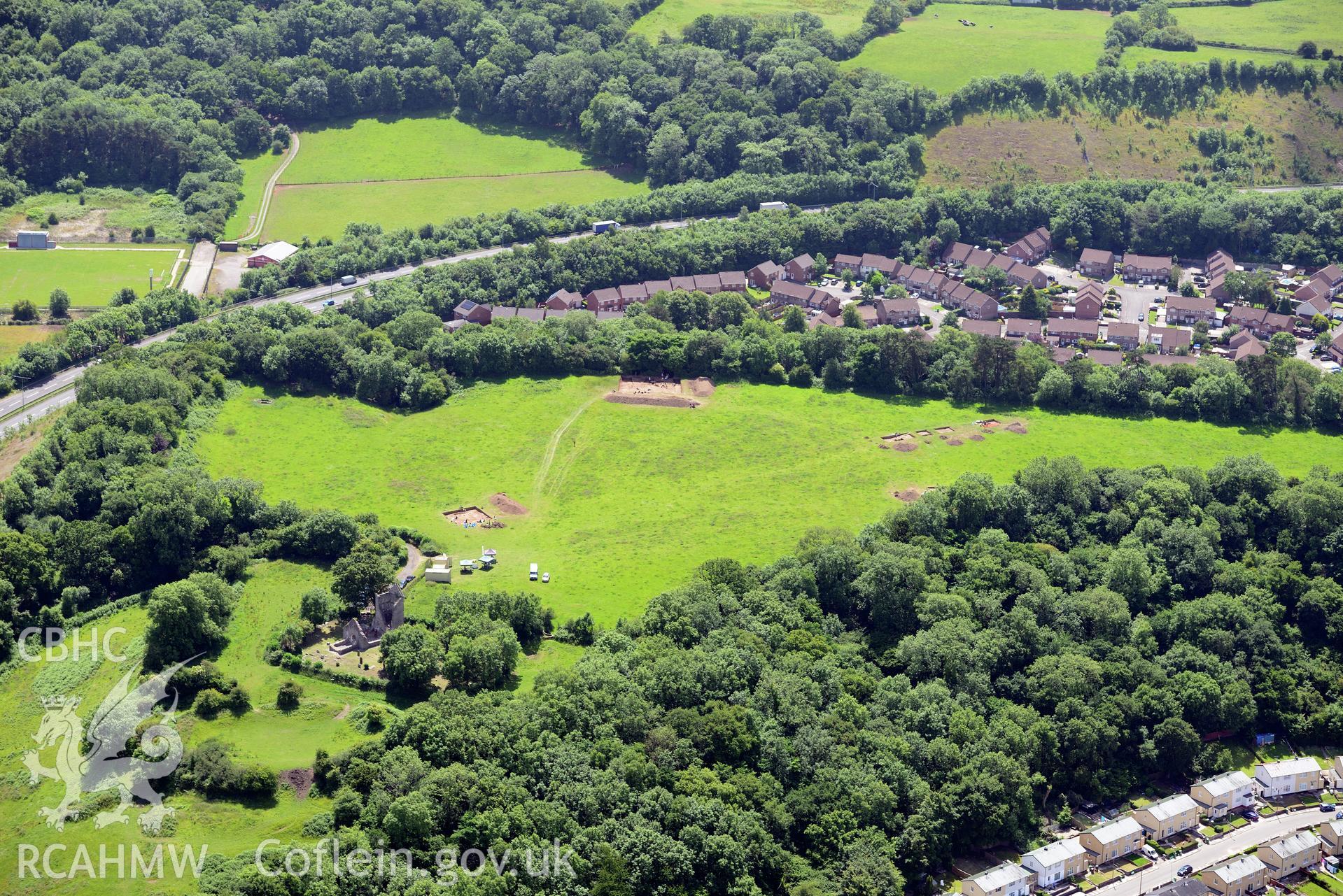 Caerau Castle Ringwork, Caerau Hillfort and the remains of St. Mary's Church, with the village of Caerau beyond. Oblique aerial photograph taken during the Royal Commission's programme of archaeological aerial reconnaissance by Toby Driver on 29/6/2015.