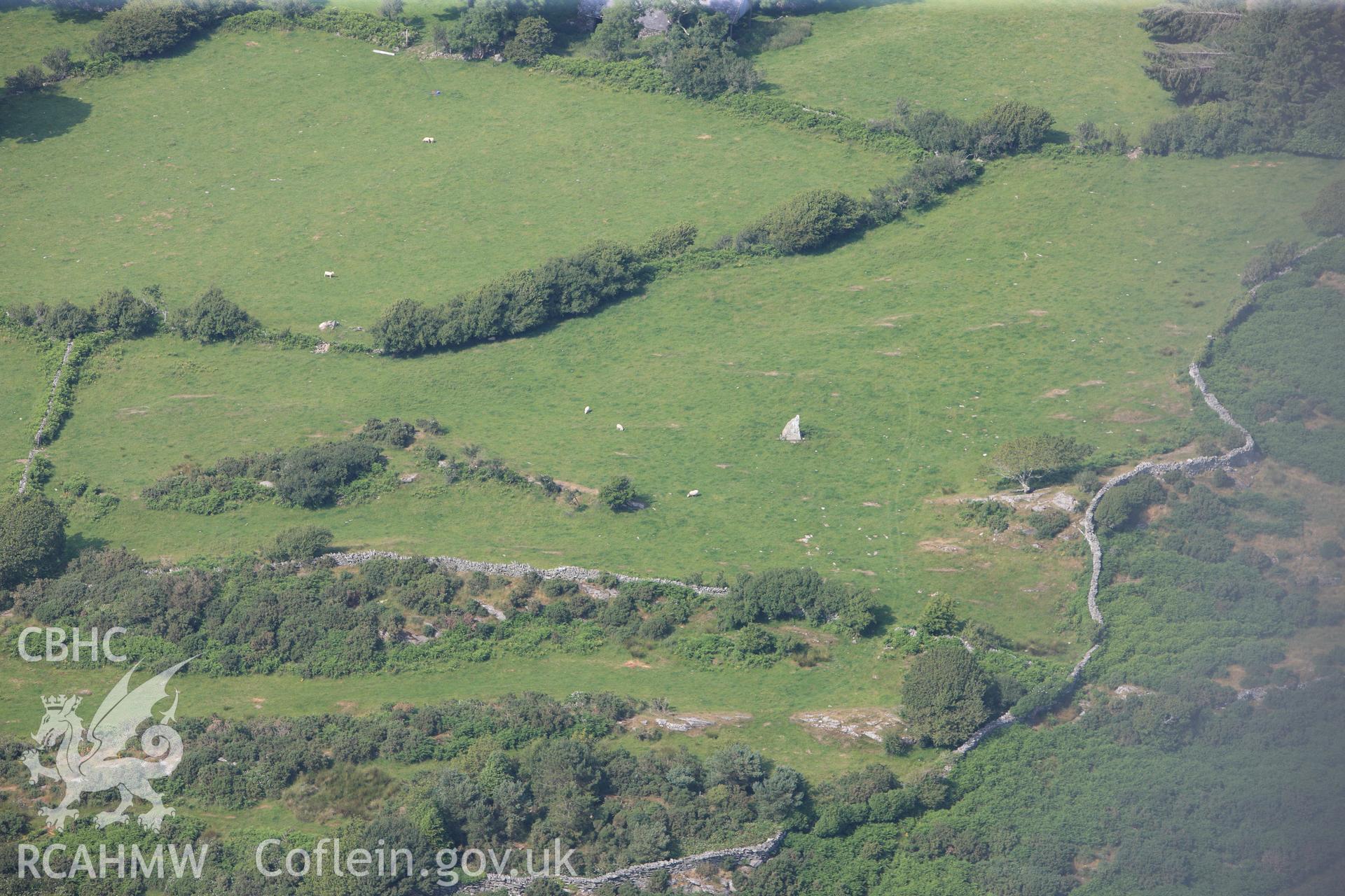 Cist Cerrig burial chamber, cup-marked outcrop and rock exposures. Oblique aerial photograph taken during the Royal Commission?s programme of archaeological aerial reconnaissance by Toby Driver on 12th July 2013.