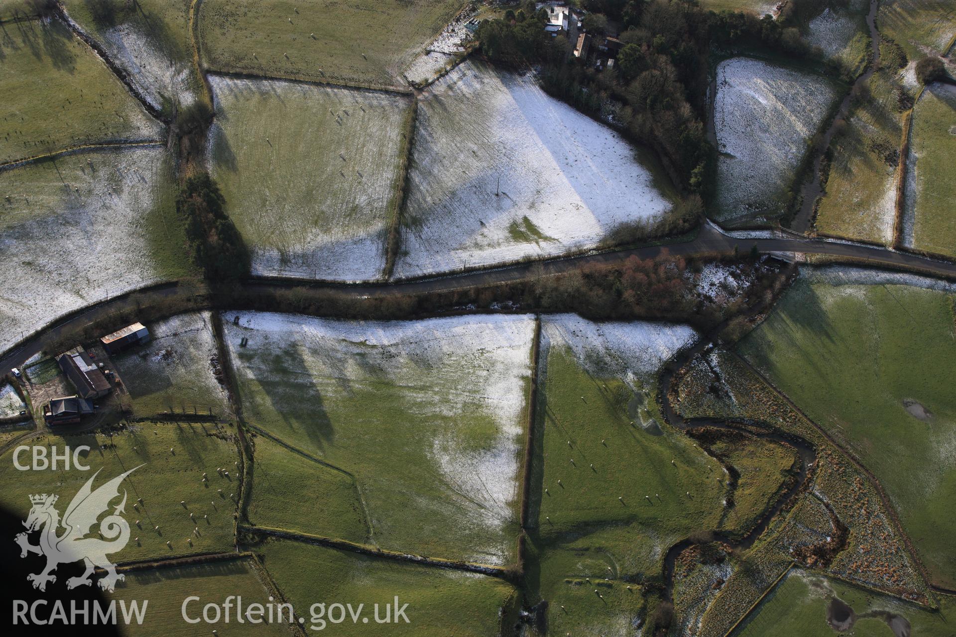 RCAHMW colour oblique photograph of The Mount round barrow, with melting snow. Taken by Toby Driver on 18/12/2011.