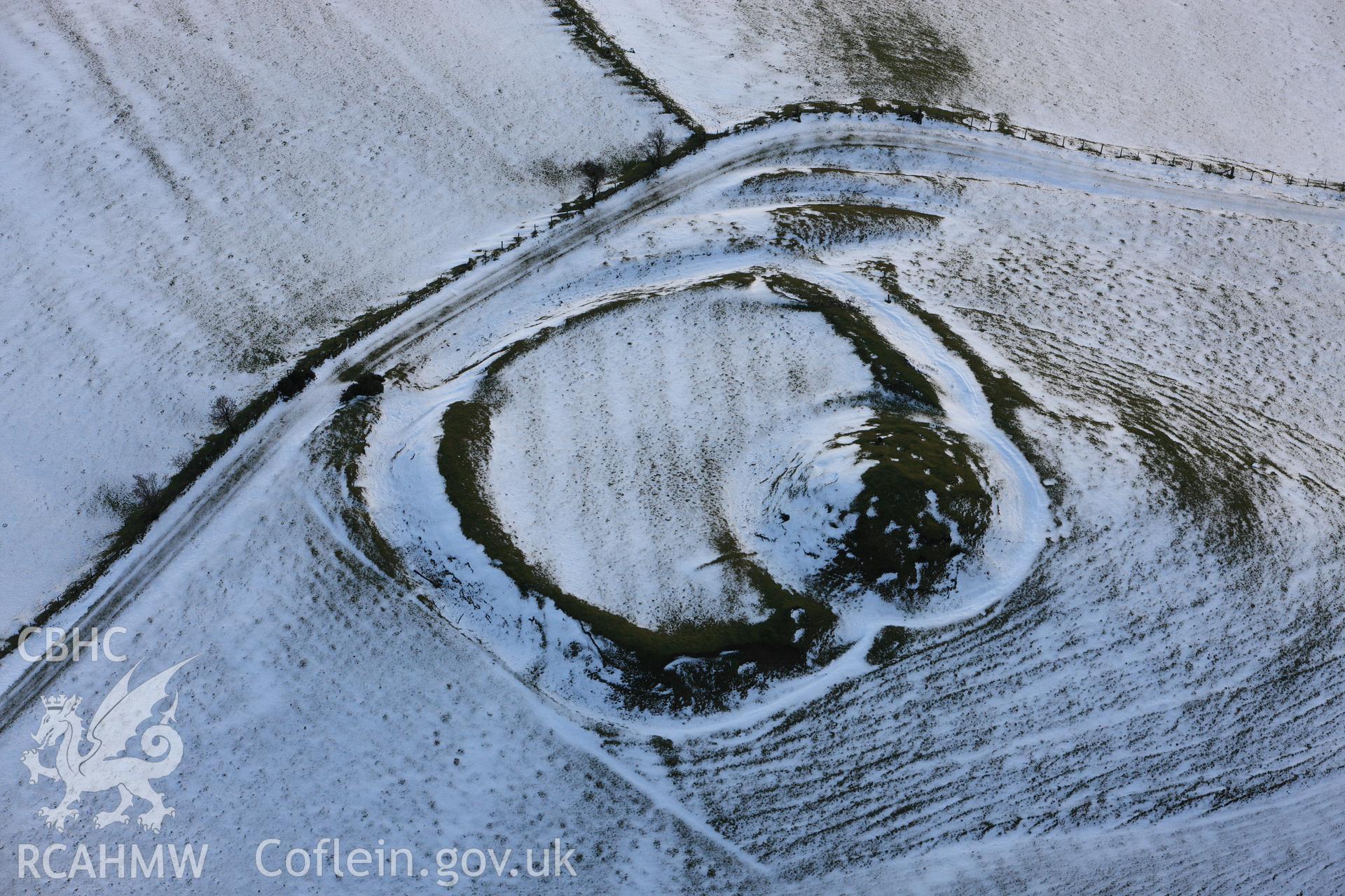 RCAHMW colour oblique photograph of Castell Crugerydd, motte and bailey under snow. Taken by Toby Driver on 18/12/2011.