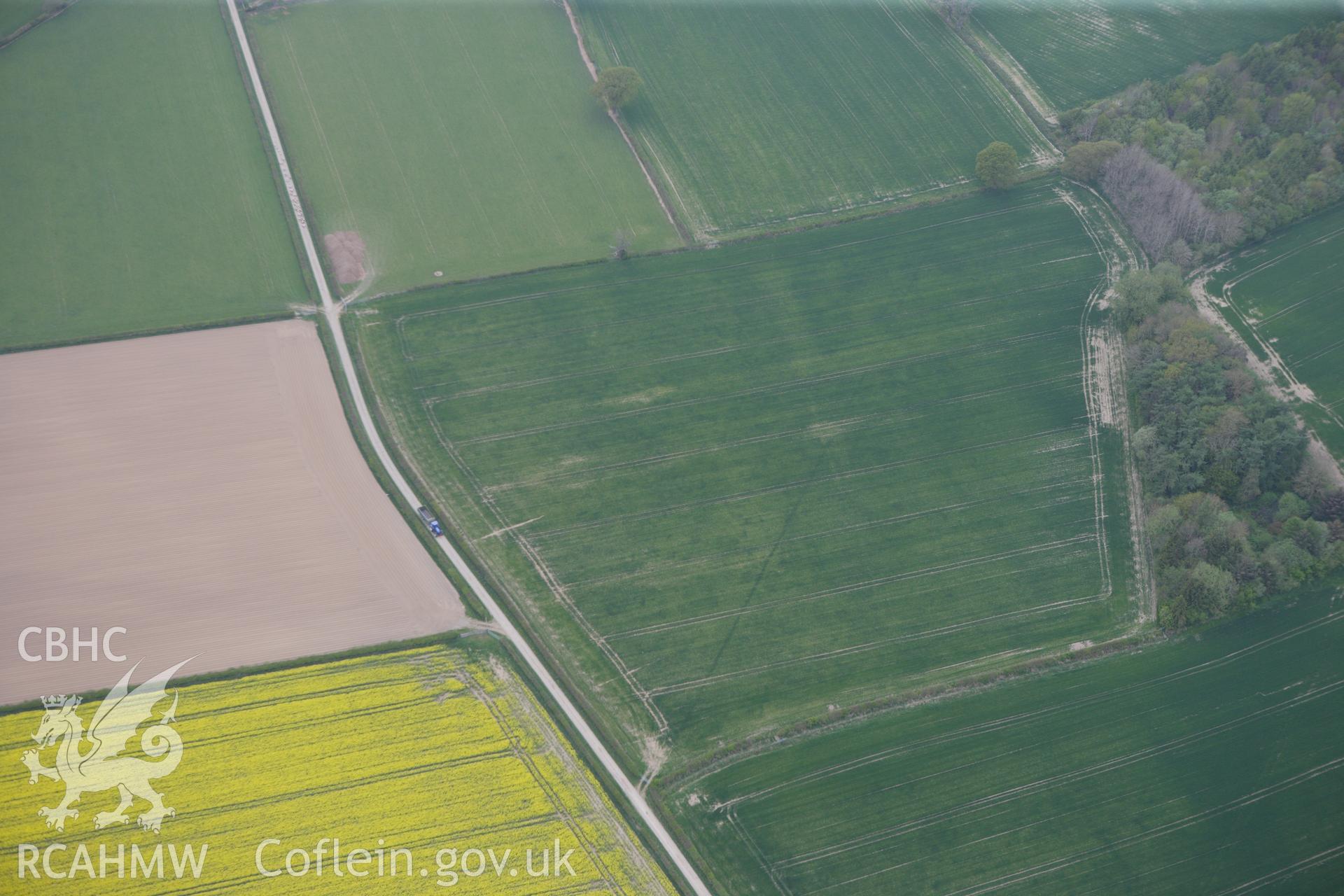 RCAHMW colour oblique photograph of Hindwell Farm marching camp and barrow. Taken by Toby Driver on 26/04/2011.