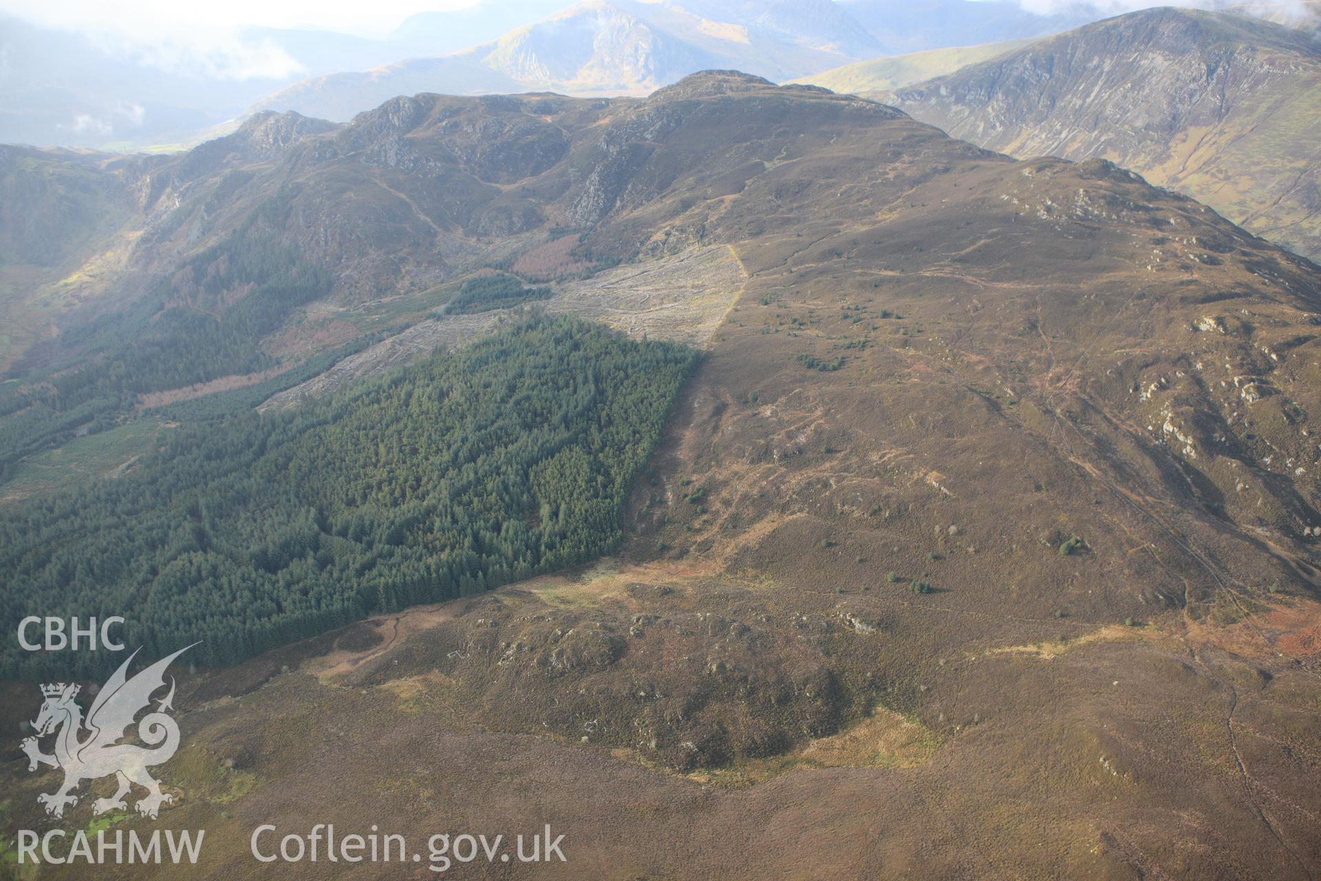 RCAHMW colour oblique photograph of Hut settlement west of Allt Goch, high view from east. Taken by Toby Driver on 13/01/2012.