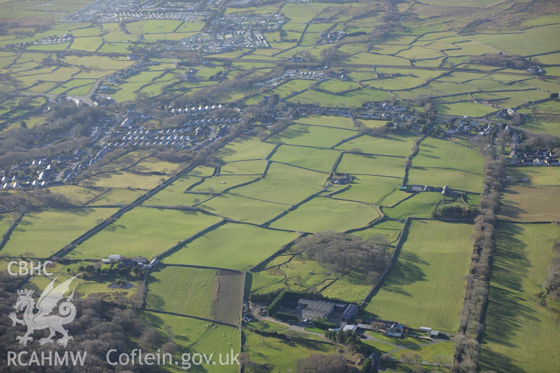 RCAHMW colour oblique photograph of Homestead, Fron Galed, and earthworks of hut circle settlement (NPRN 403536) from the east. Taken by Toby Driver on 10/12/2012.