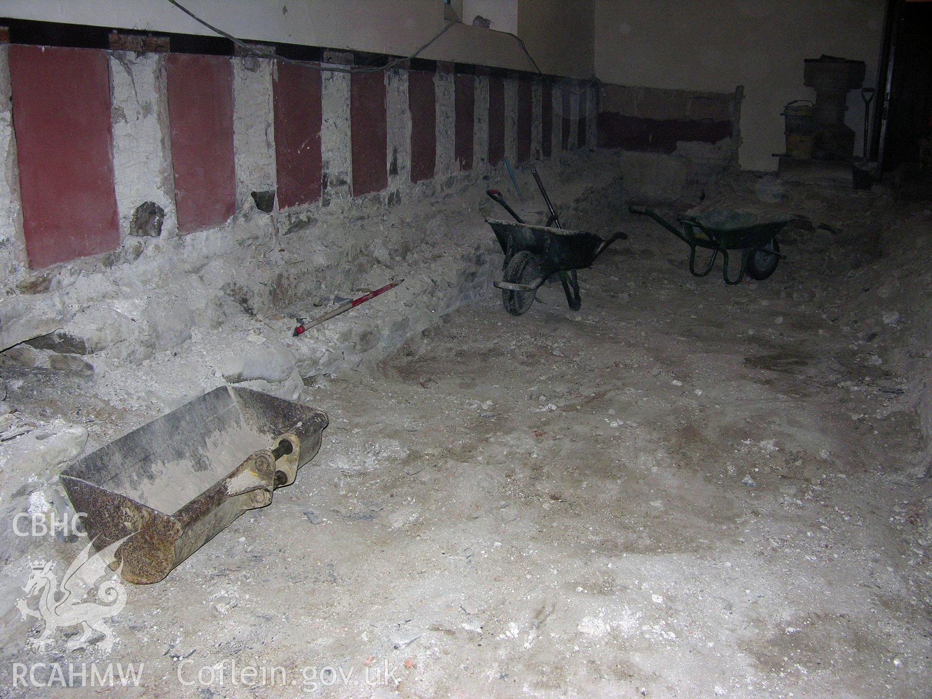 Digital colour photograph showing view of the church wall foundation level, exposed after removal of floorboards, joists and rubble fill from hollow area - part of an archaeological watching brief for St Michaels Church, Trefeglwys, Powys (CAP Report 602) by Chris E. Smith.