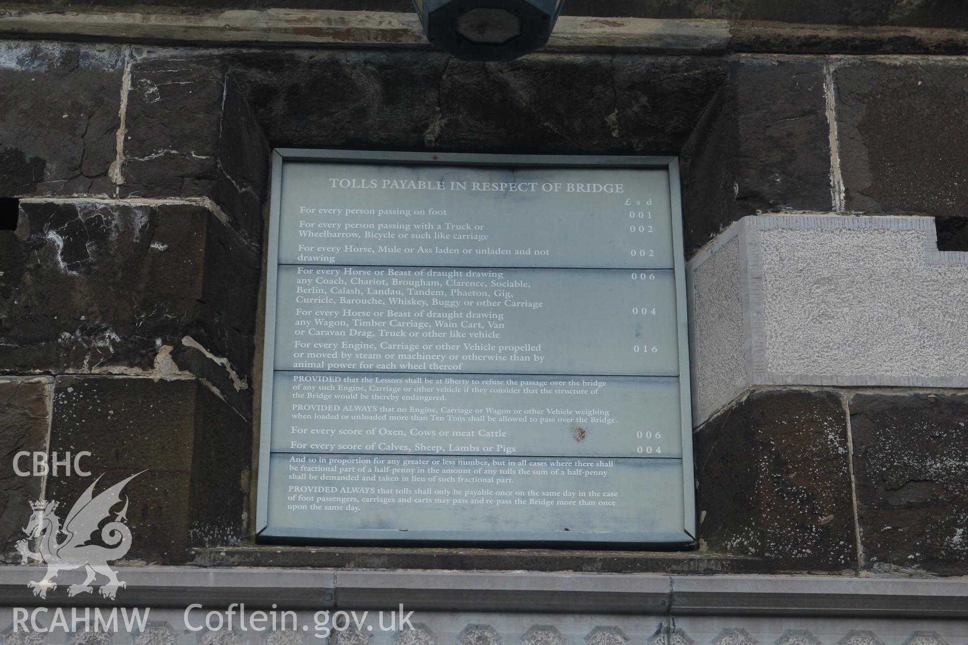 Investigator photographs of Conwy Suspension Bridge Keepers cottage. Exterior: replica of board displaying the historic toll rates collected for crossing the bridge.