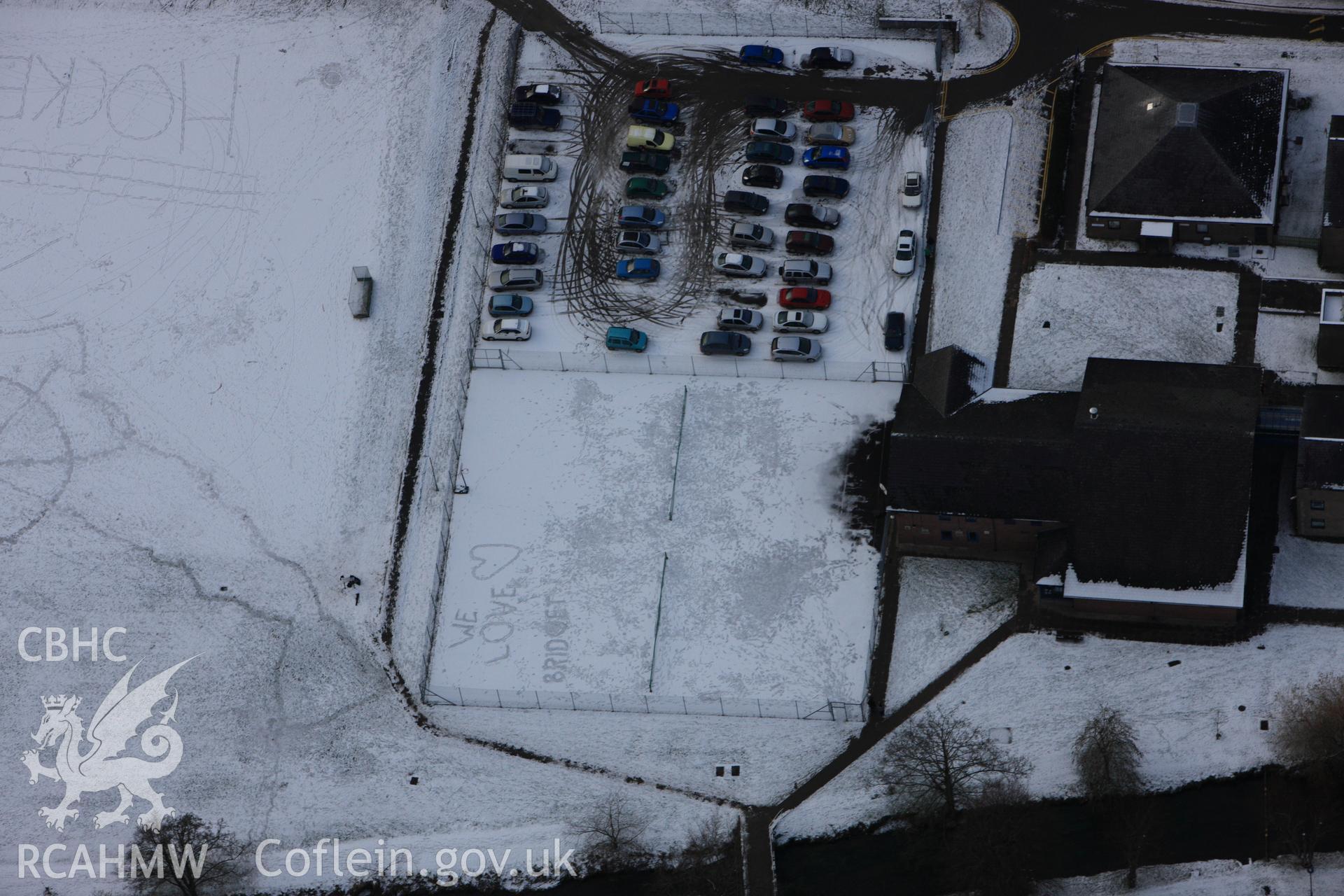 RCAHMW colour oblique photograph of Lampeter University, with names written in snow on hockey pitch. Taken by Toby Driver on 02/12/2010.