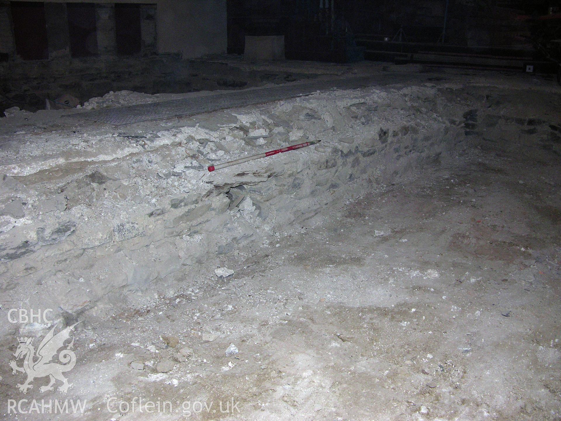 Digital colour photograph showing view of central aisle containing heating flue, scale 1x1m - part of an archaeological watching brief for St Michaels Church, Trefeglwys, Powys (CAP Report 602) by Chris E. Smith.