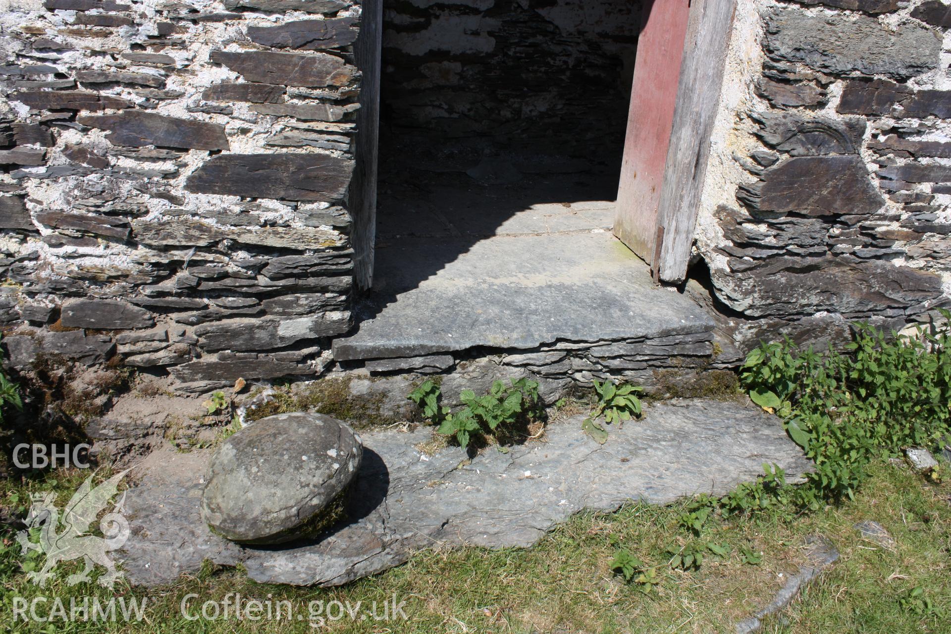 'The worn step of the main doorway, with a geological curiosity (a nodule) kept alongside.' Photographed by Richard Suggett of RCAHMW in June 2020.