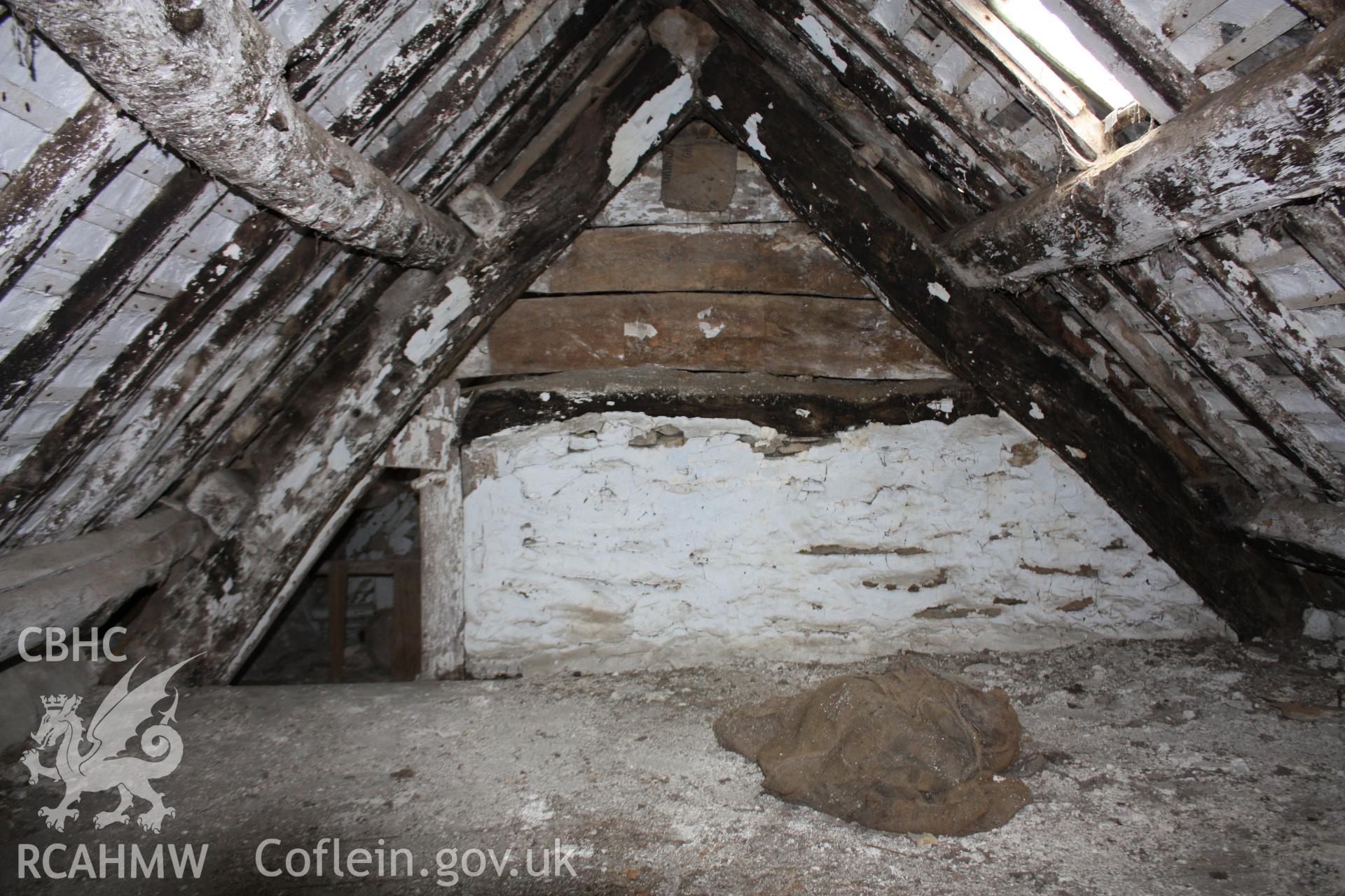 Smoke-blackened cruck-blades against the inserted chimney. Photographed by Richard Suggett of RCAHMW in June 2020.