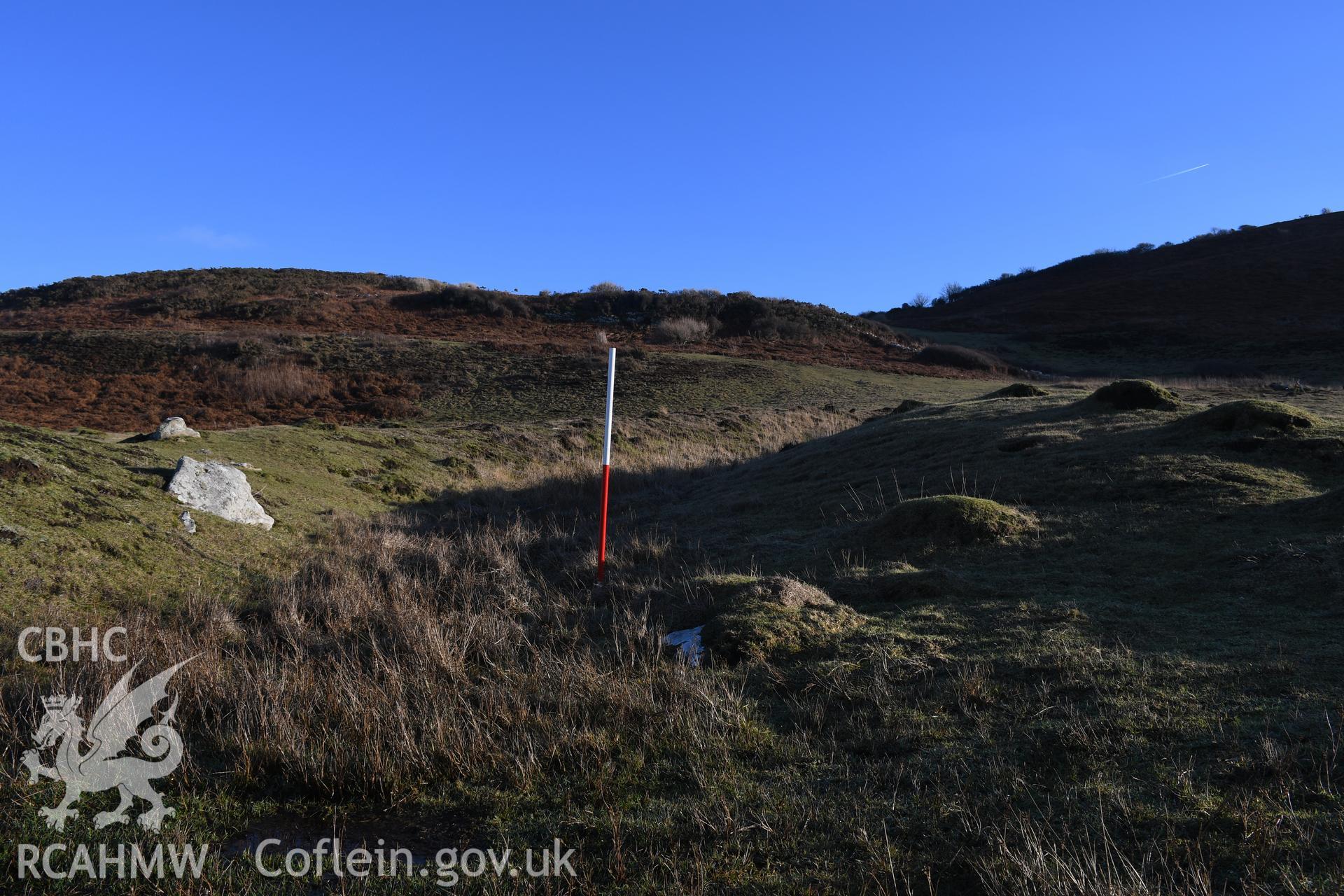 Gate remains at N end of inner ramparts. Camera facing SE. 1m scale. From photographic survey of Castell Bach promontory fort (NPRN 93914) using 1m scales and human figures. Undertaken by Hannah Genders Boyd for CHERISH project condition monitoring 13/01/2022.
Produced with EU funds through the Ireland Wales Co-operation Programme 2014-2020. All material made freely available through the Open Government Licence.