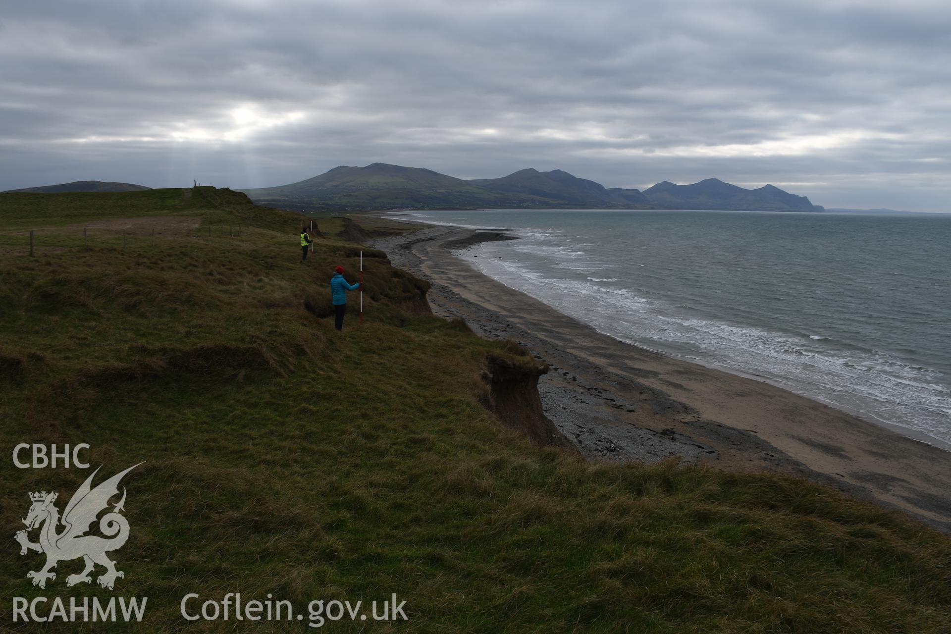 Looking south along the eroding coast from the hillfort. 2 figures and 2 x 2m scales. Taken by Hannah Genders Boyd. Produced with EU funds through the Ireland Wales Co-operation Programme 2014-2023. All material made freely available through the Open Gove