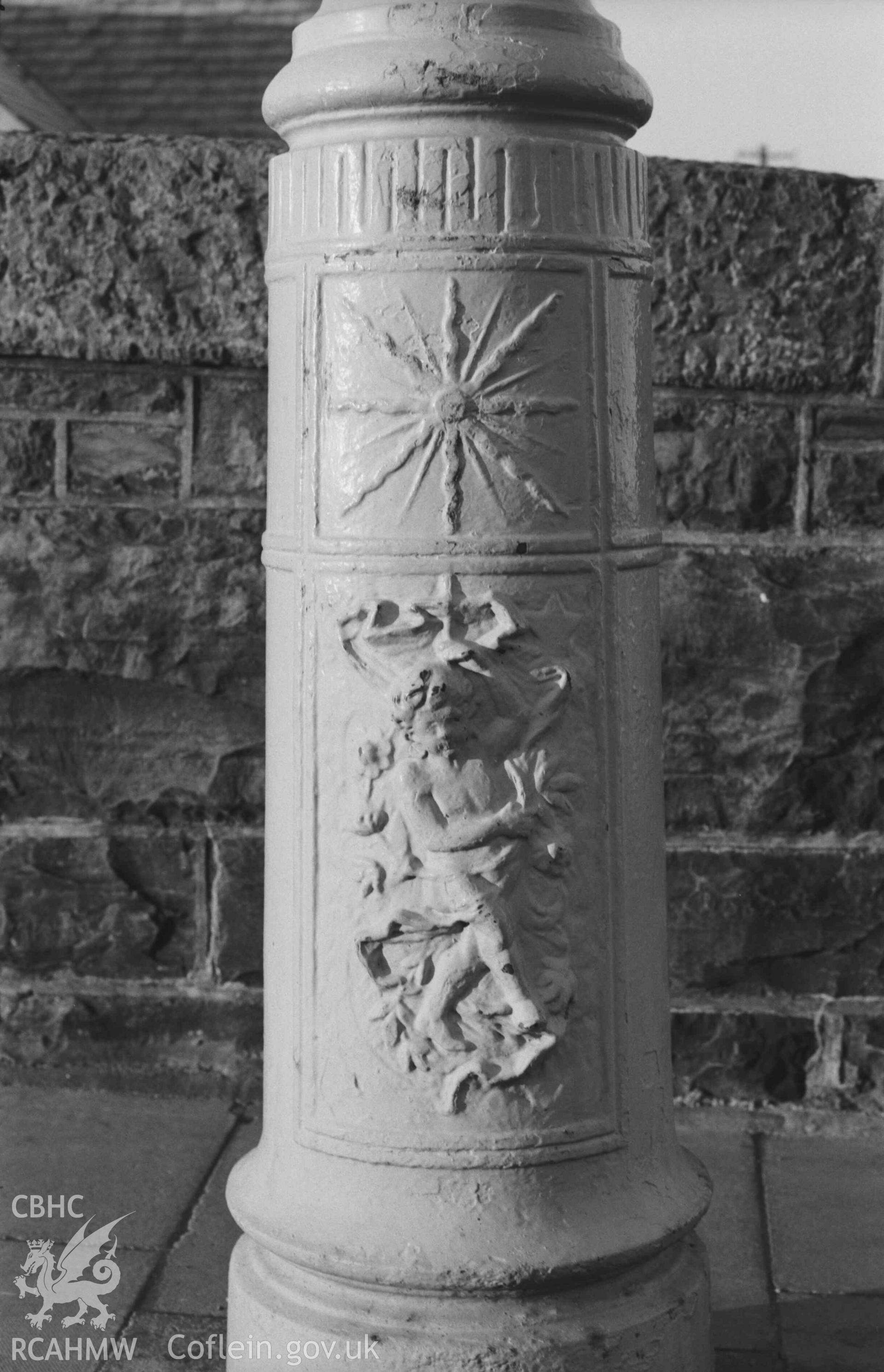 Digital copy of a black and white negative showing base of lamp post on pavement at north end of west side of Trefechan Bridge. Photographed by Arthur Chater on 27 December 1968. Looking west from Grid Reference SN 5827 8137.