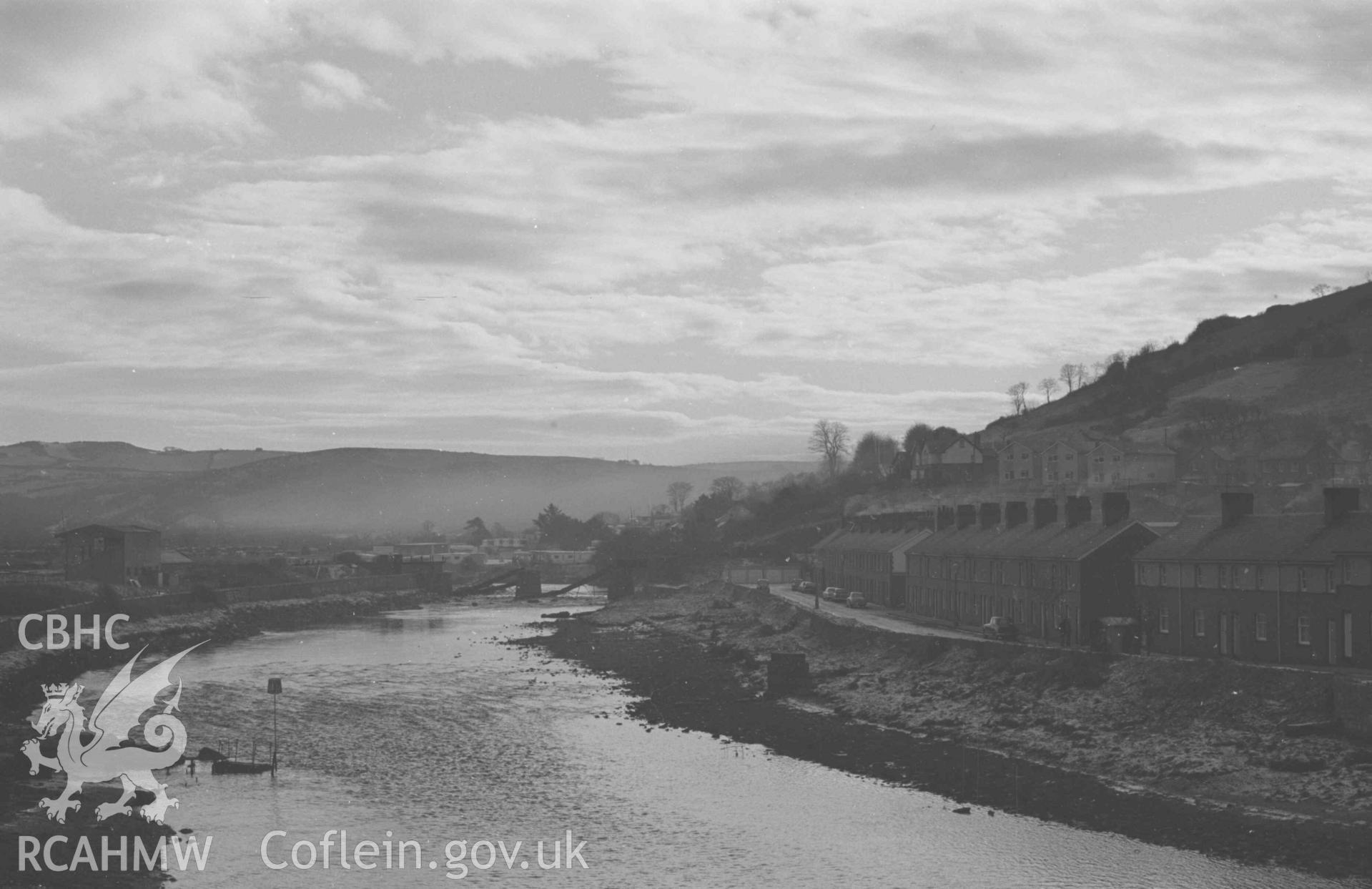 Digital copy of a black and white negative showing the Rheidol river with Glanyrafon Terrace, Trefechan, on the right, and Aberystwyth Town Football Ground on the left. Railway bridge beyond. Photographed by Arthur Chater on 28 December 1968.