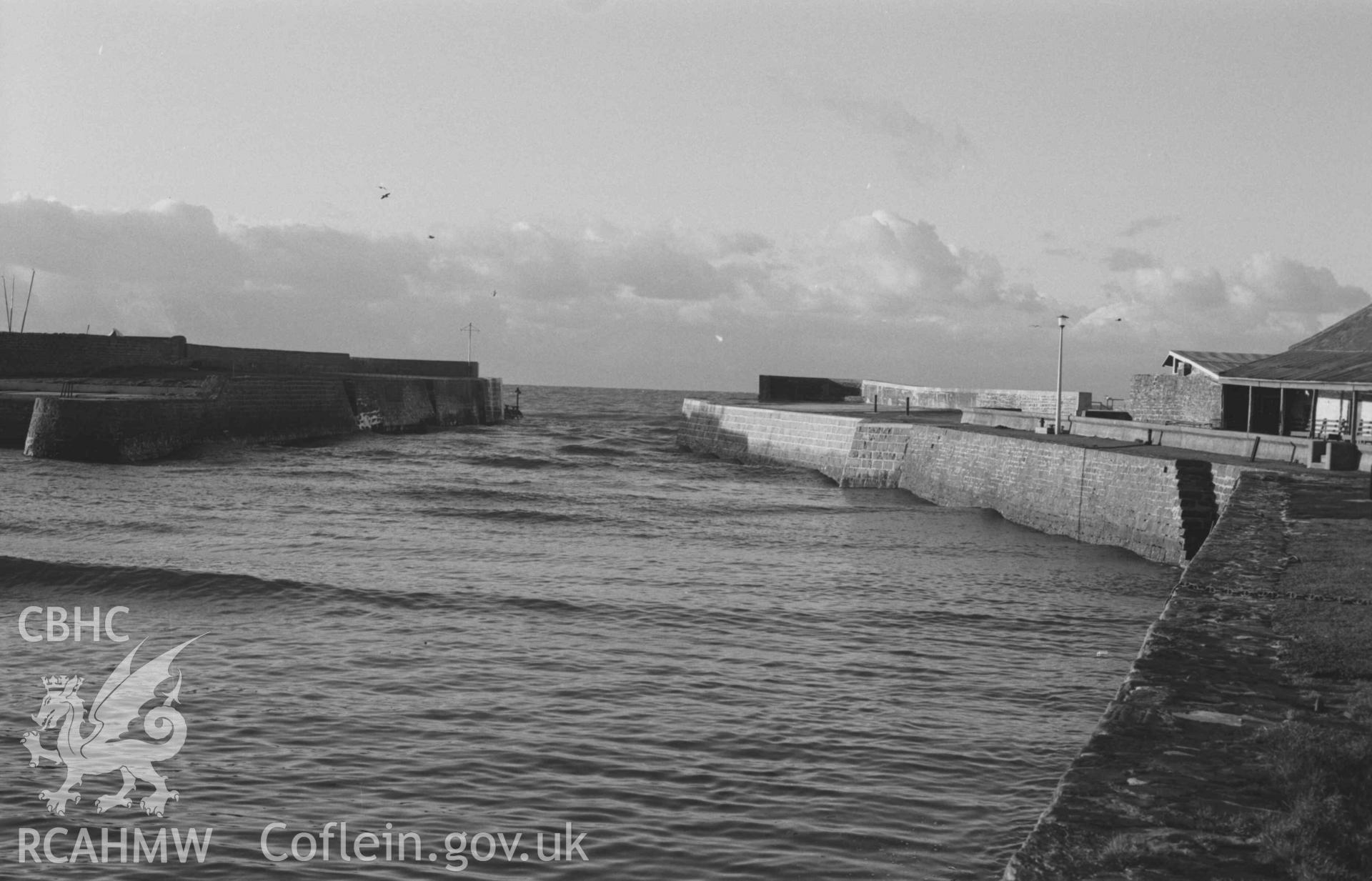 Digital copy of a black and white negative showing the entrance to Aberaeron harbour from Quay Parade. Photographed by Arthur Chater on 28 December 1968. Looking north west from Grid Reference SN 4560 6294.