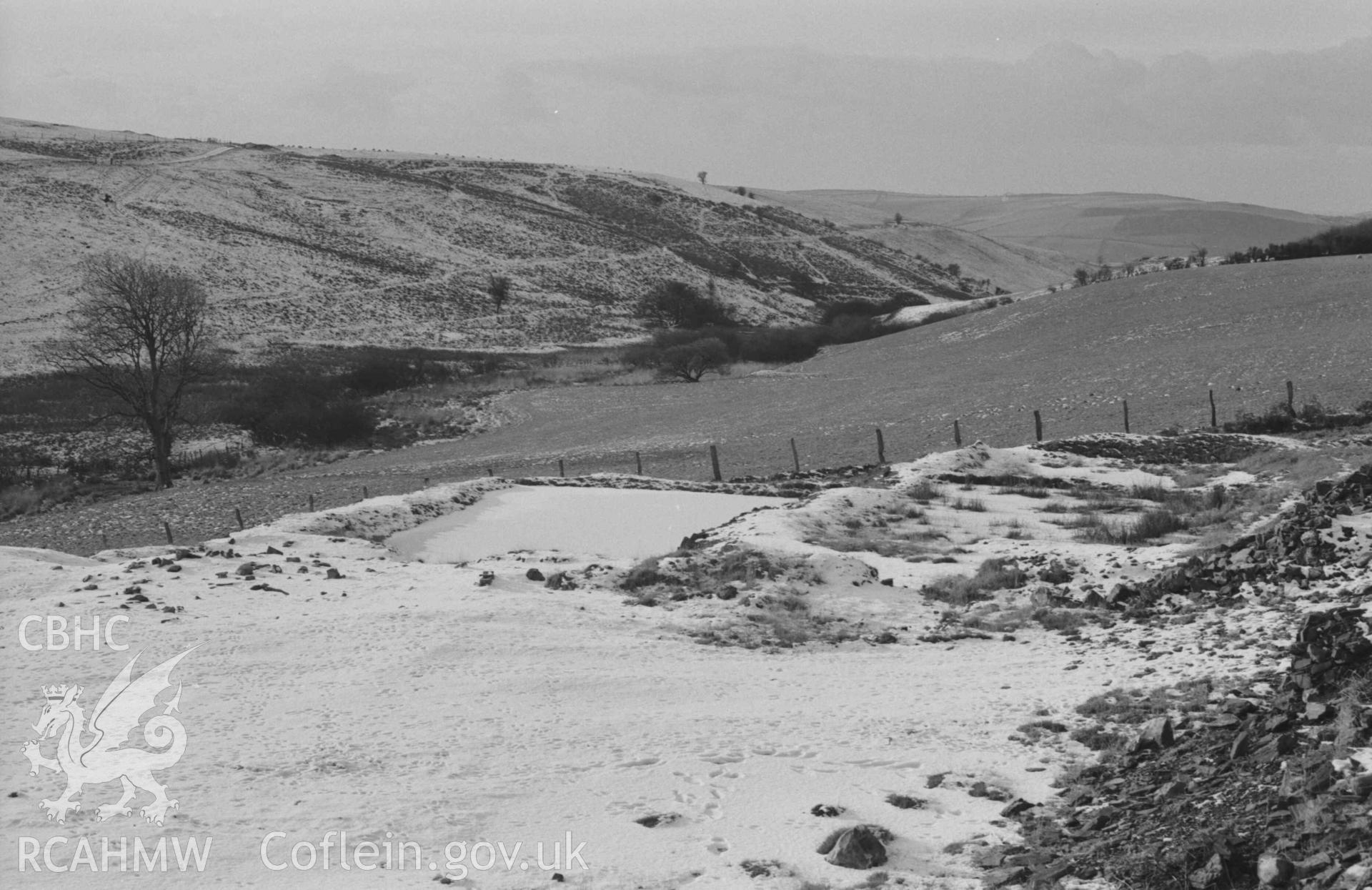 Digital copy of a black and white negative showing settling tanks on the west side of Mynydd-Gorddu mine, near the lower end. Photographed by Arthur Chater on 29 December 1968. Looking south west from Grid Reference SN 6674 8598.