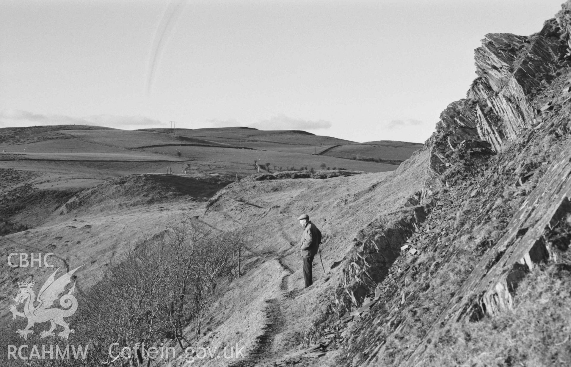 Digital copy of a black and white negative showing view looking along the footpath below the south western ramparts of Castell Bwa Drain. Photographed by Arthur Chater on 5 January 1969. Looking west north west from Grid Reference SN 7130 7940.