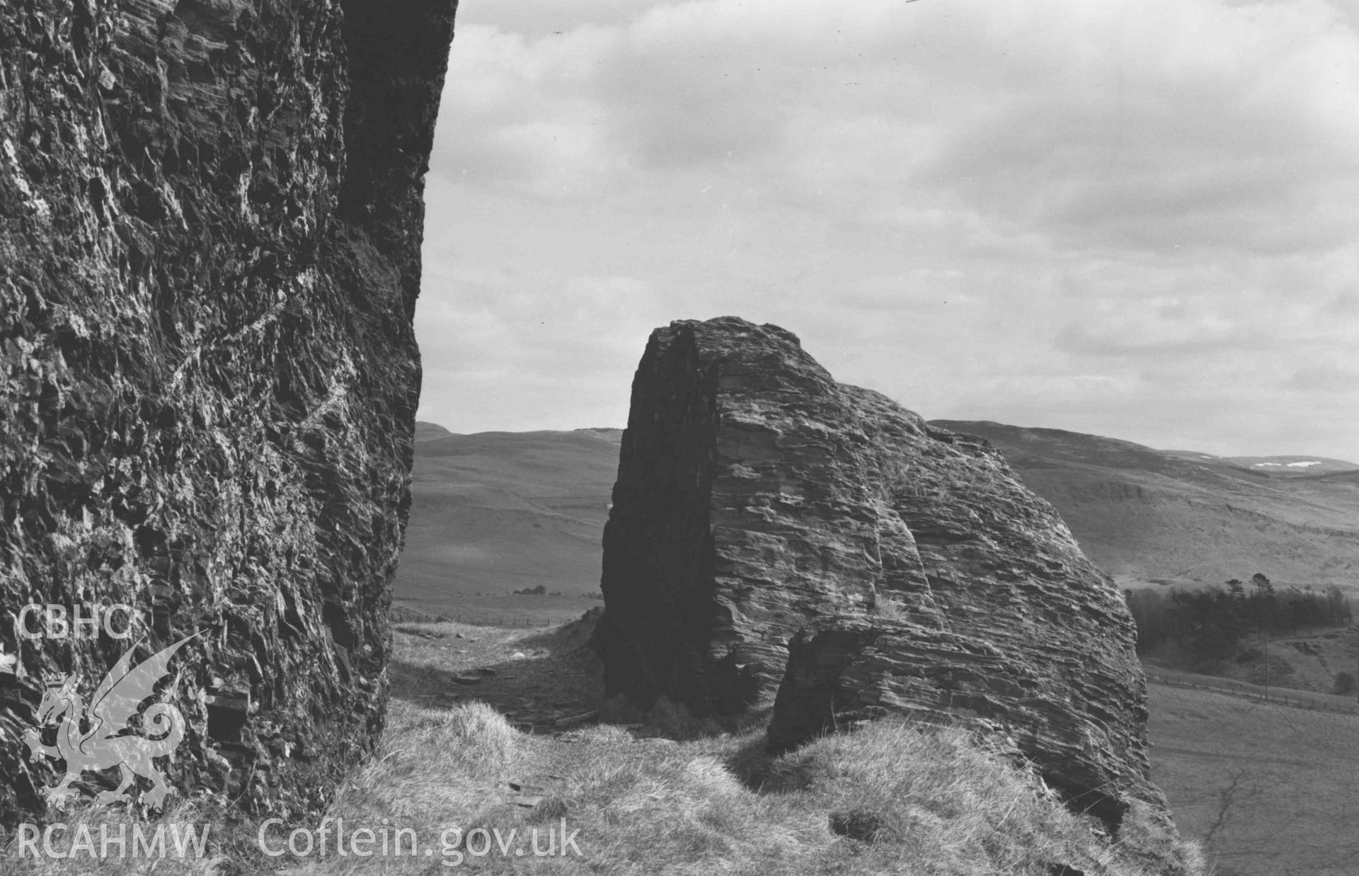 Digital copy of a black and white negative showing rock cutting of acqueduct on hillside 100m north of Ffynnon-Cadno. Photographed by Arthur Chater on 2 April 1969. Looking east from Grid Reference SN 7409 8071.