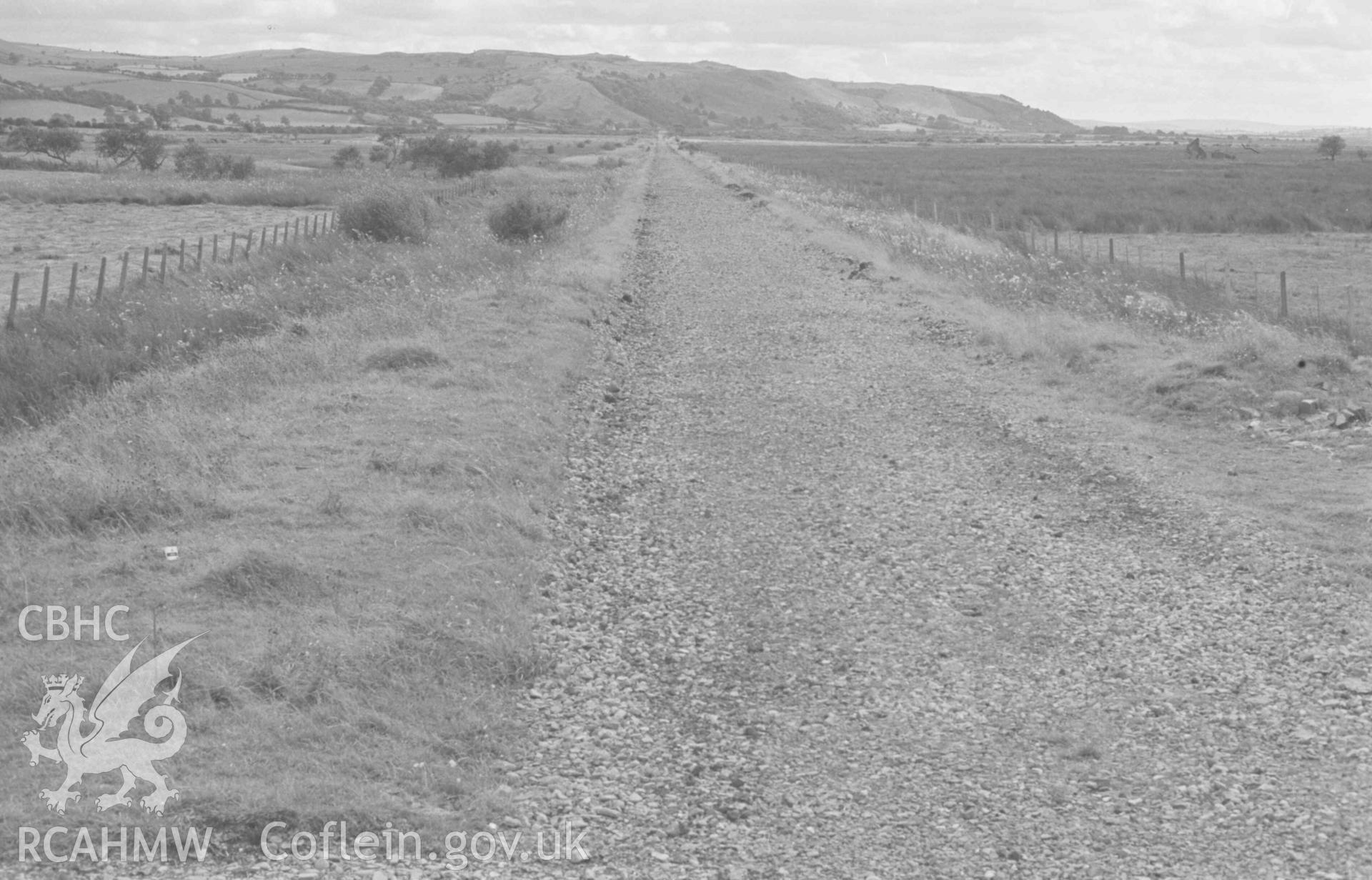 Digital copy of a black and white negative showing view from the railway bridge over the Teifi looking down the disused railway line to the halt at Allt-Ddu; the ruins of Dol-Glan-Teifi on extreme right. Photographed by Arthur Chater on 18 August 1968. Looking south south west from Grid Reference SN 709 664.