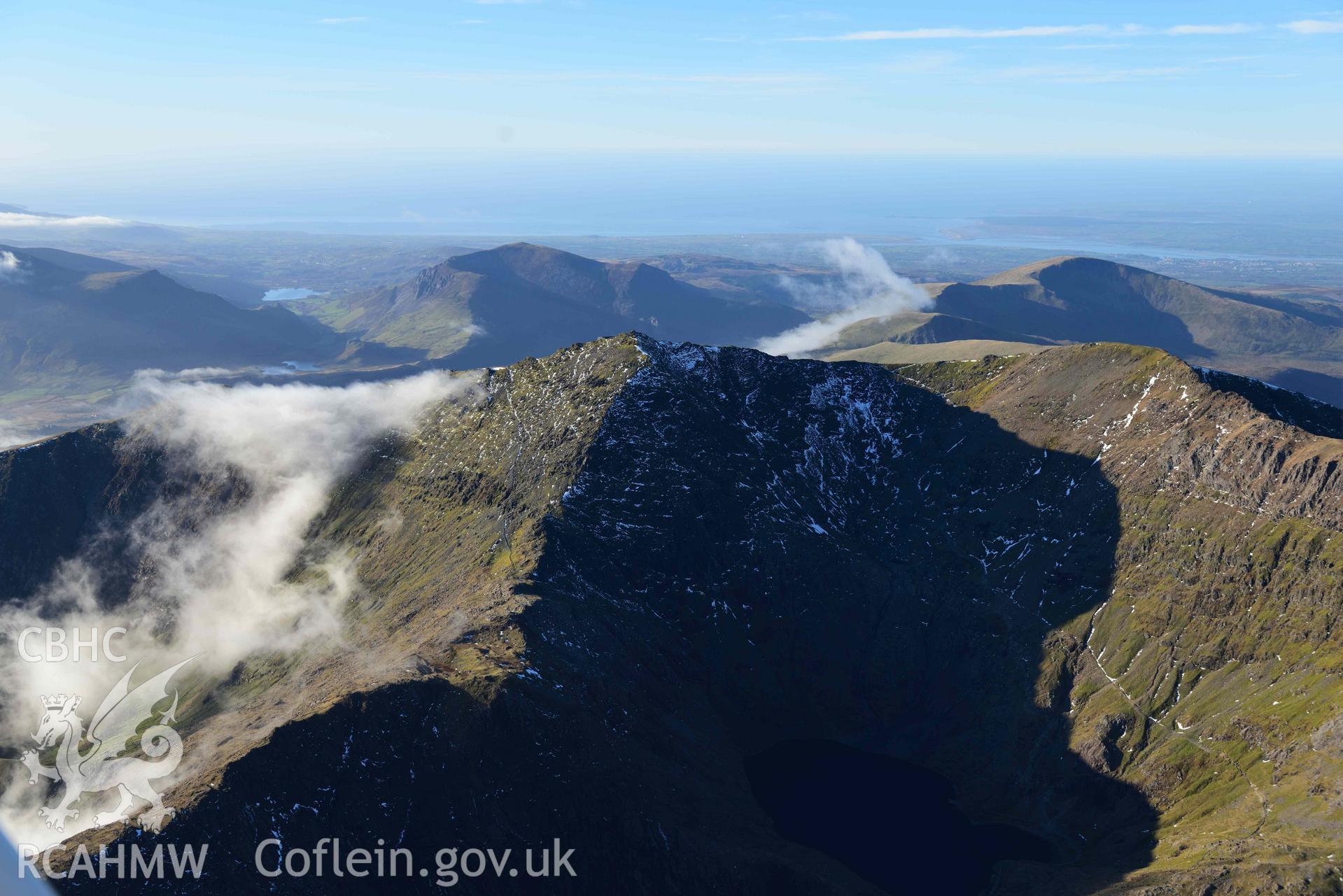 Oblique aerial photograph of Snowdon summit and mountain landscape, taken from the east during the Royal Commission’s programme of archaeological aerial reconnaissance by Toby Driver on 12th January 2022