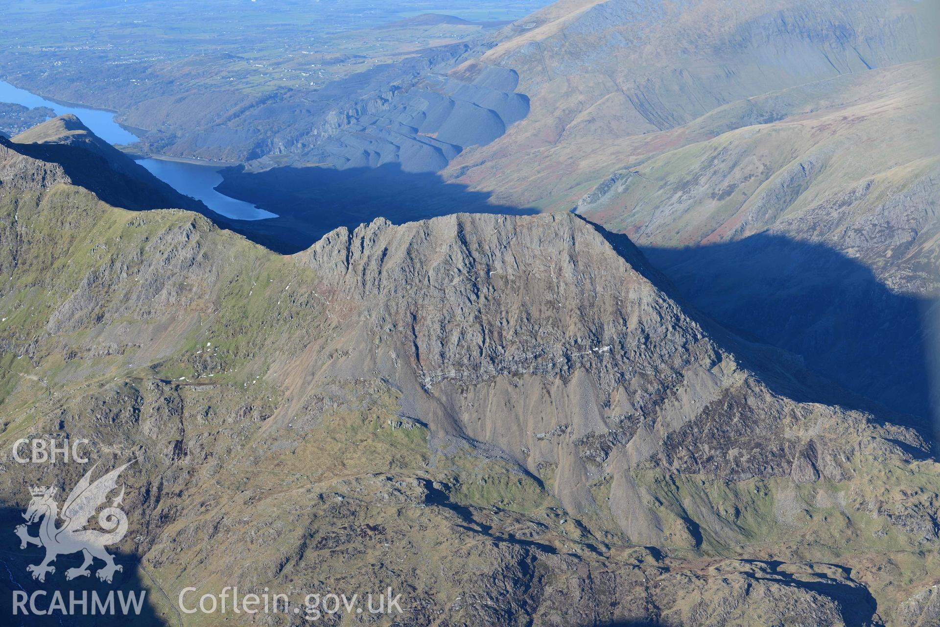 Oblique aerial photograph of Snowdon mountain landscape with Crib Goch ridge, taken from the south during the Royal Commission’s programme of archaeological aerial reconnaissance by Toby Driver on 12th January 2022