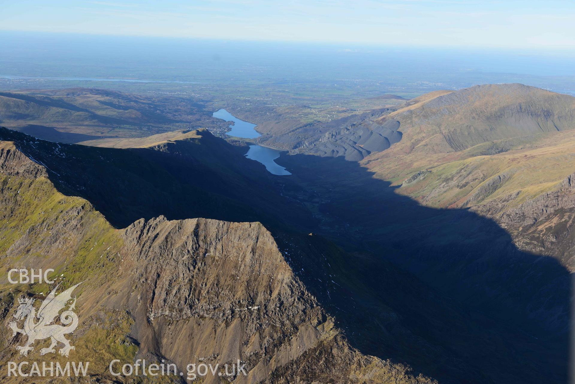 Oblique aerial photograph of Snowdon mountain landscape with Crib Goch ridge, taken from the south east during the Royal Commission’s programme of archaeological aerial reconnaissance by Toby Driver on 12th January 2022