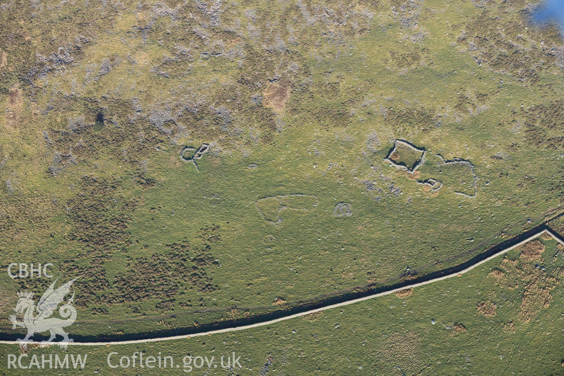 Oblique aerial photograph of hut group and enclosures on south west slopes of Moelfre taken during the Royal Commission