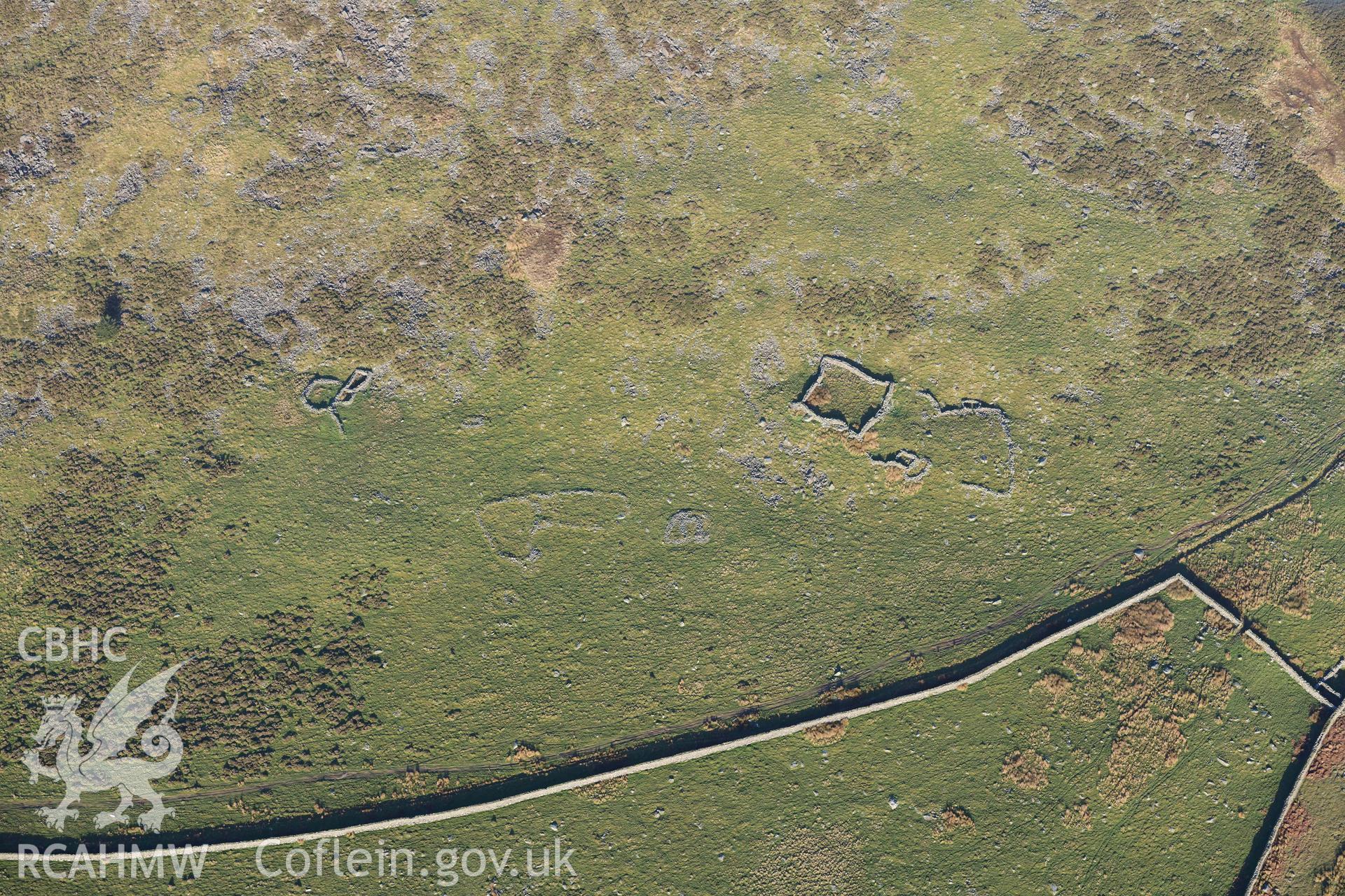 Oblique aerial photograph of hut group and enclosures on south west slopes of Moelfre taken during the Royal Commission