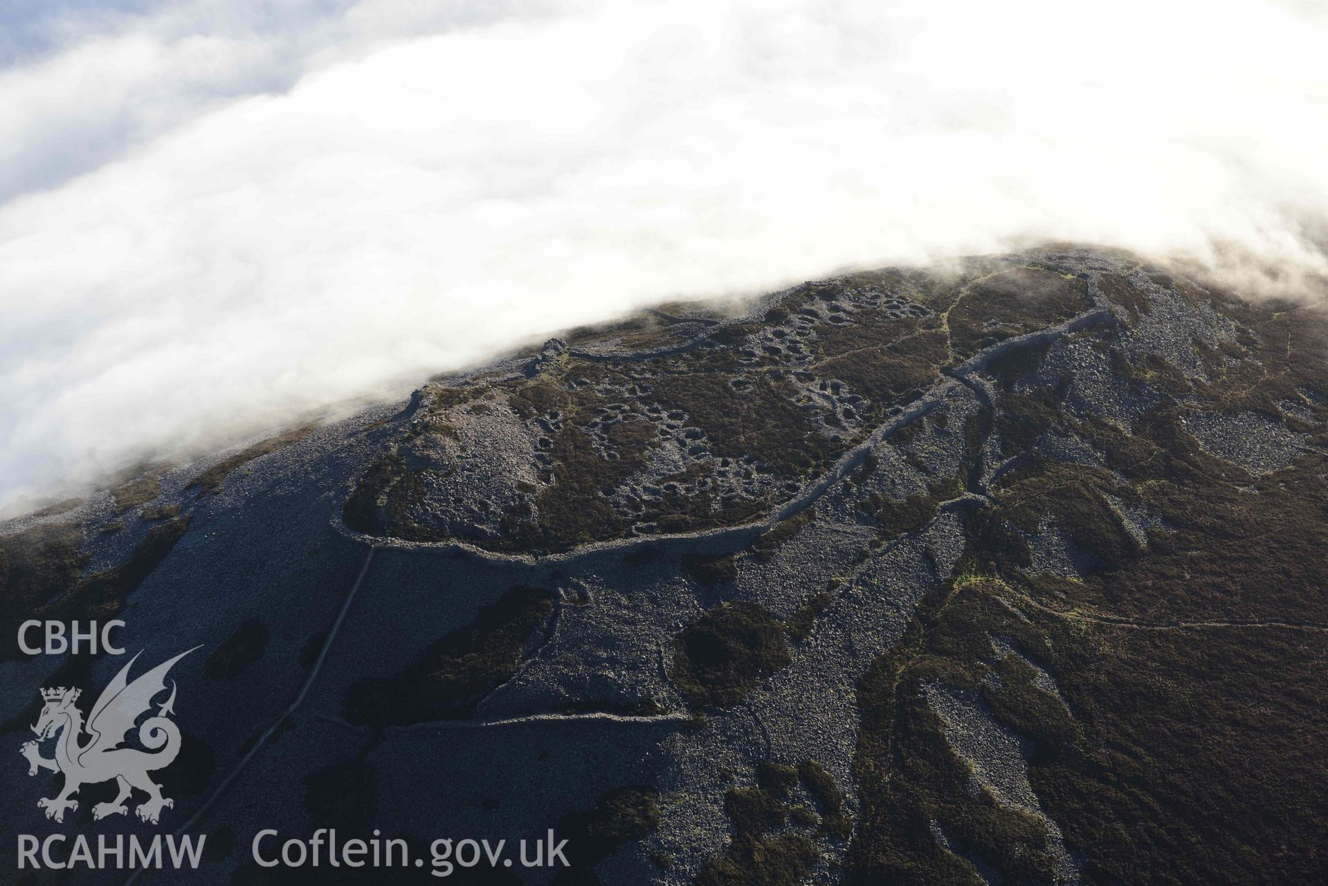 Oblique aerial photograph of Tre'r Ceiri, with cloud inversion, taken during the Royal Commission