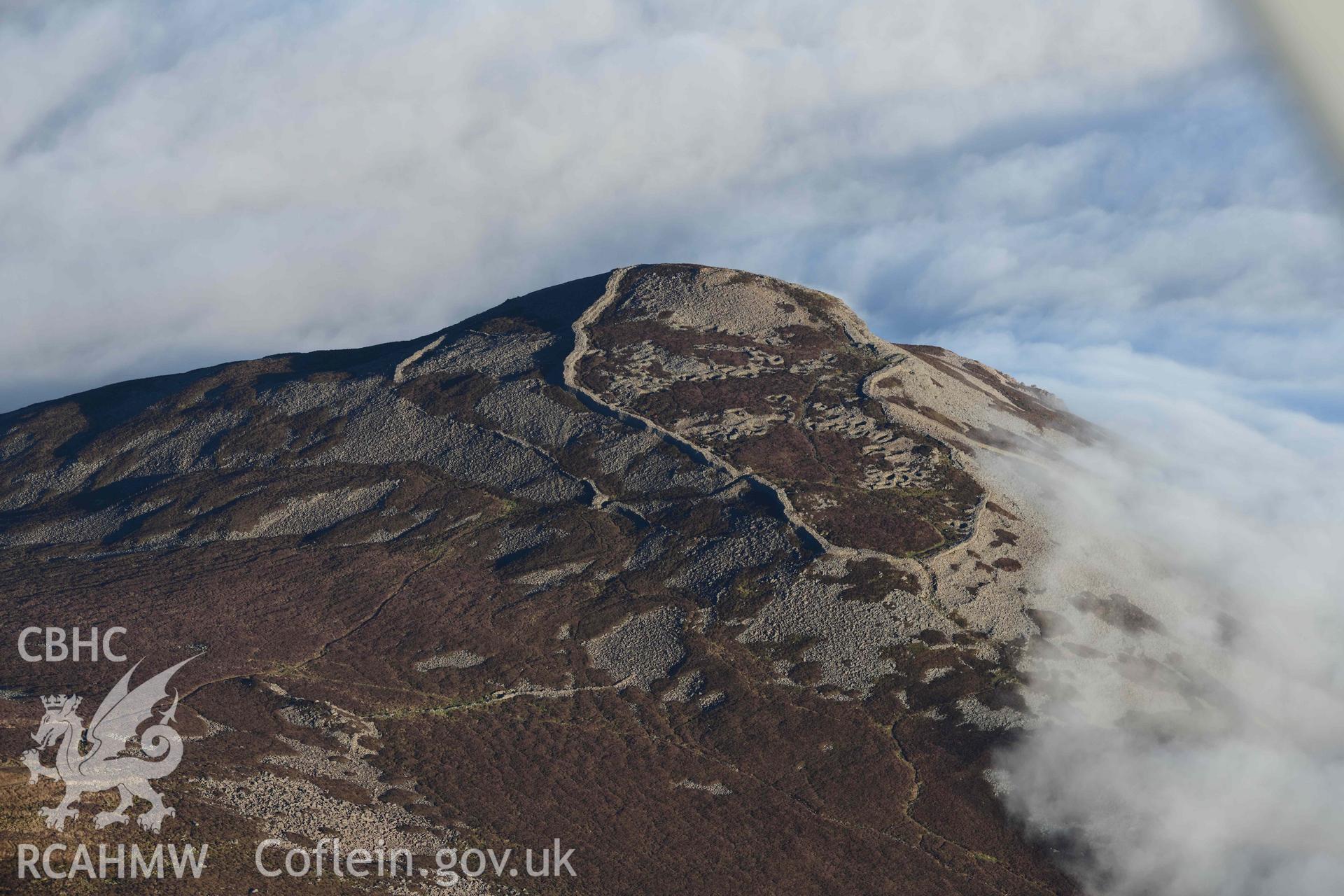 Oblique aerial photograph of Tre'r Ceiri, with cloud inversion, taken during the Royal Commission