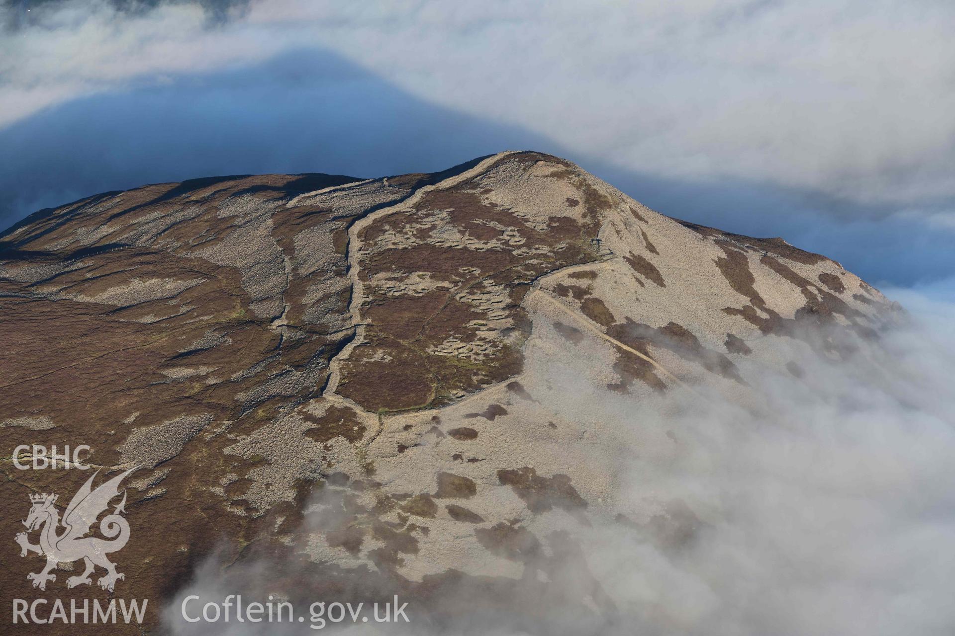 Oblique aerial photograph of Tre'r Ceiri, with cloud inversion, taken during the Royal Commission