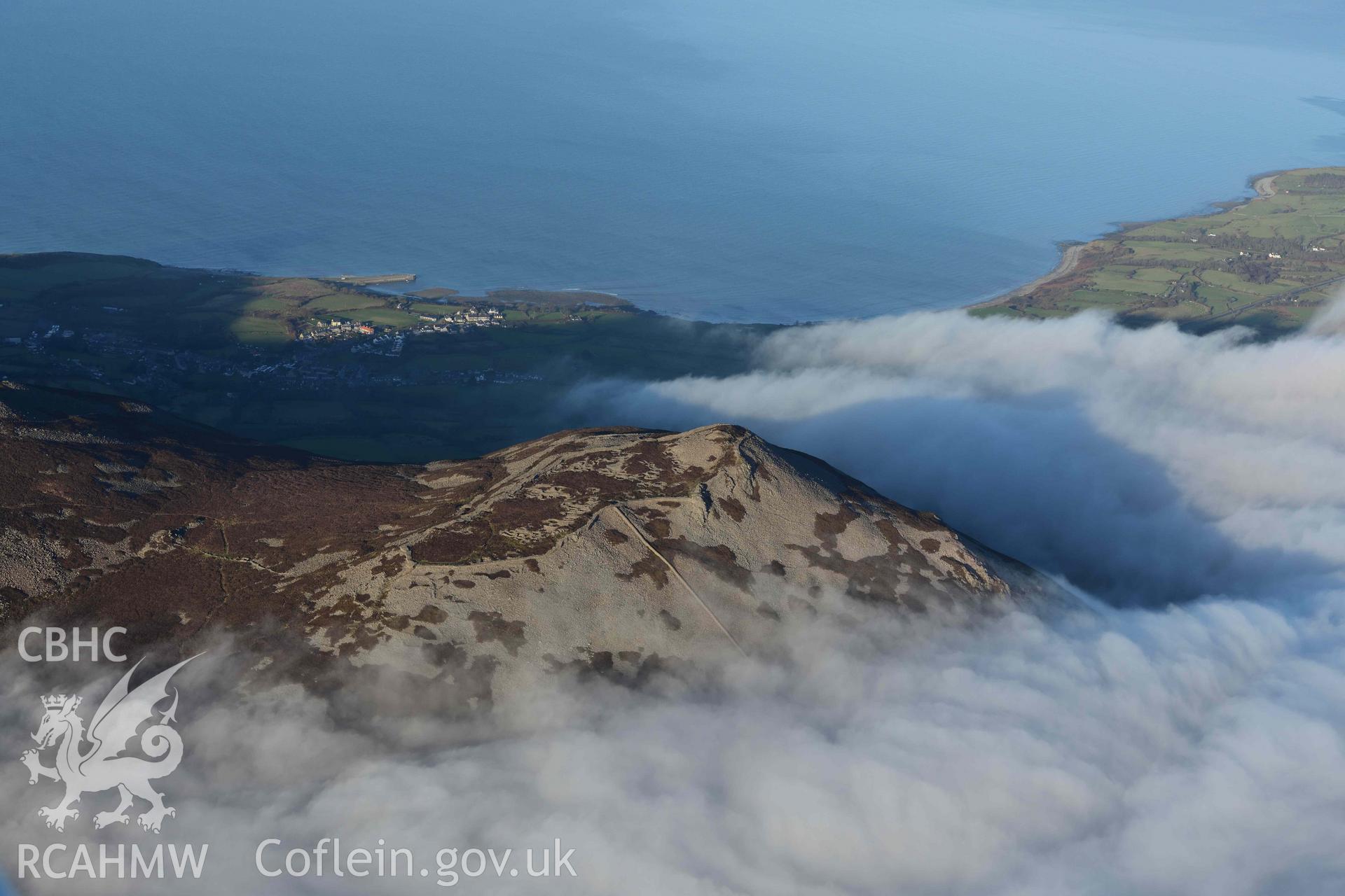 Oblique aerial photograph of Tre'r Ceiri, with cloud inversion, taken during the Royal Commission