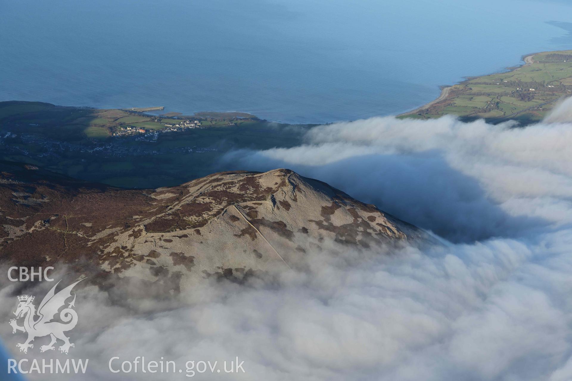 Oblique aerial photograph of Tre'r Ceiri, with cloud inversion, taken during the Royal Commission