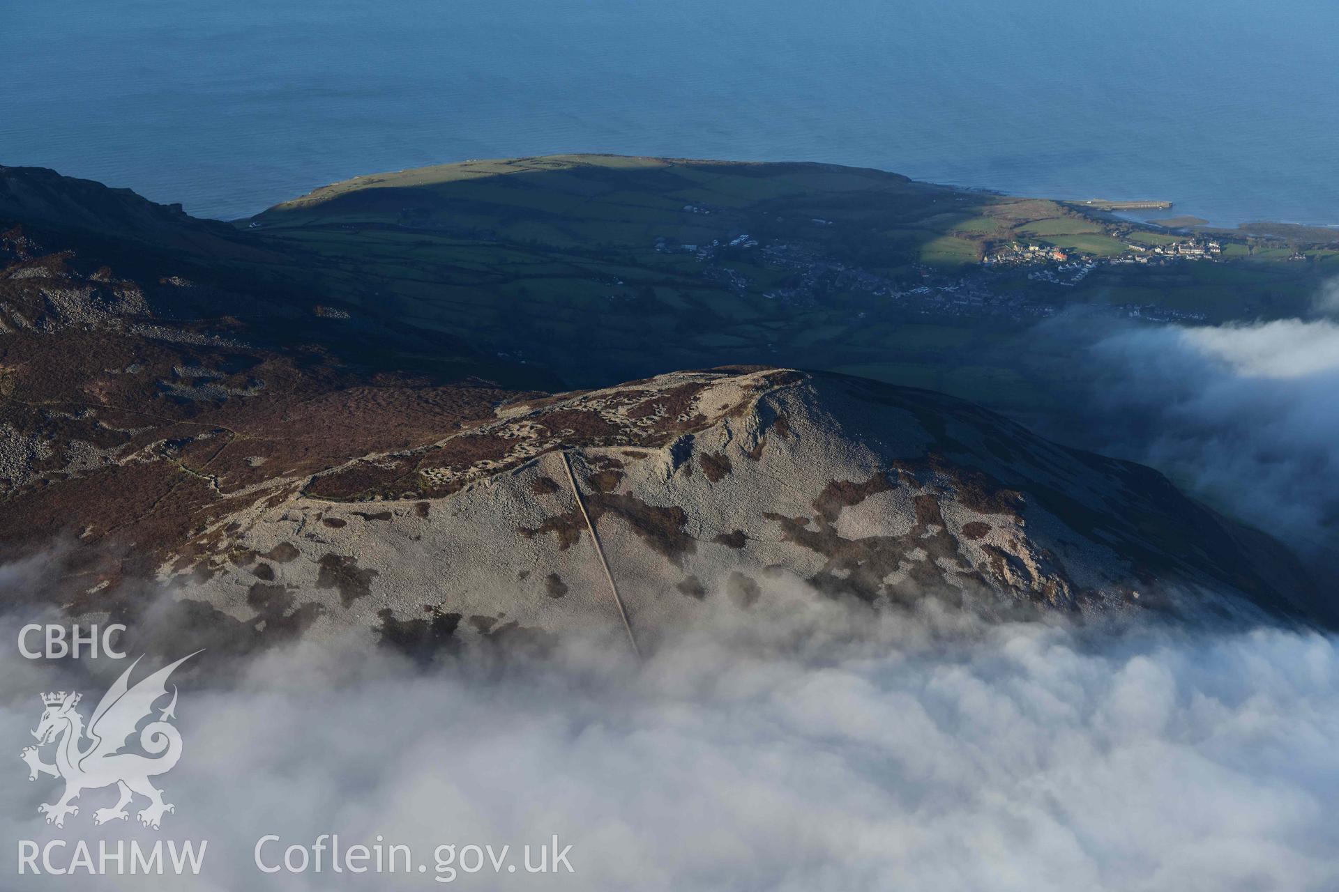 Oblique aerial photograph of Tre'r Ceiri, with cloud inversion, taken during the Royal Commission