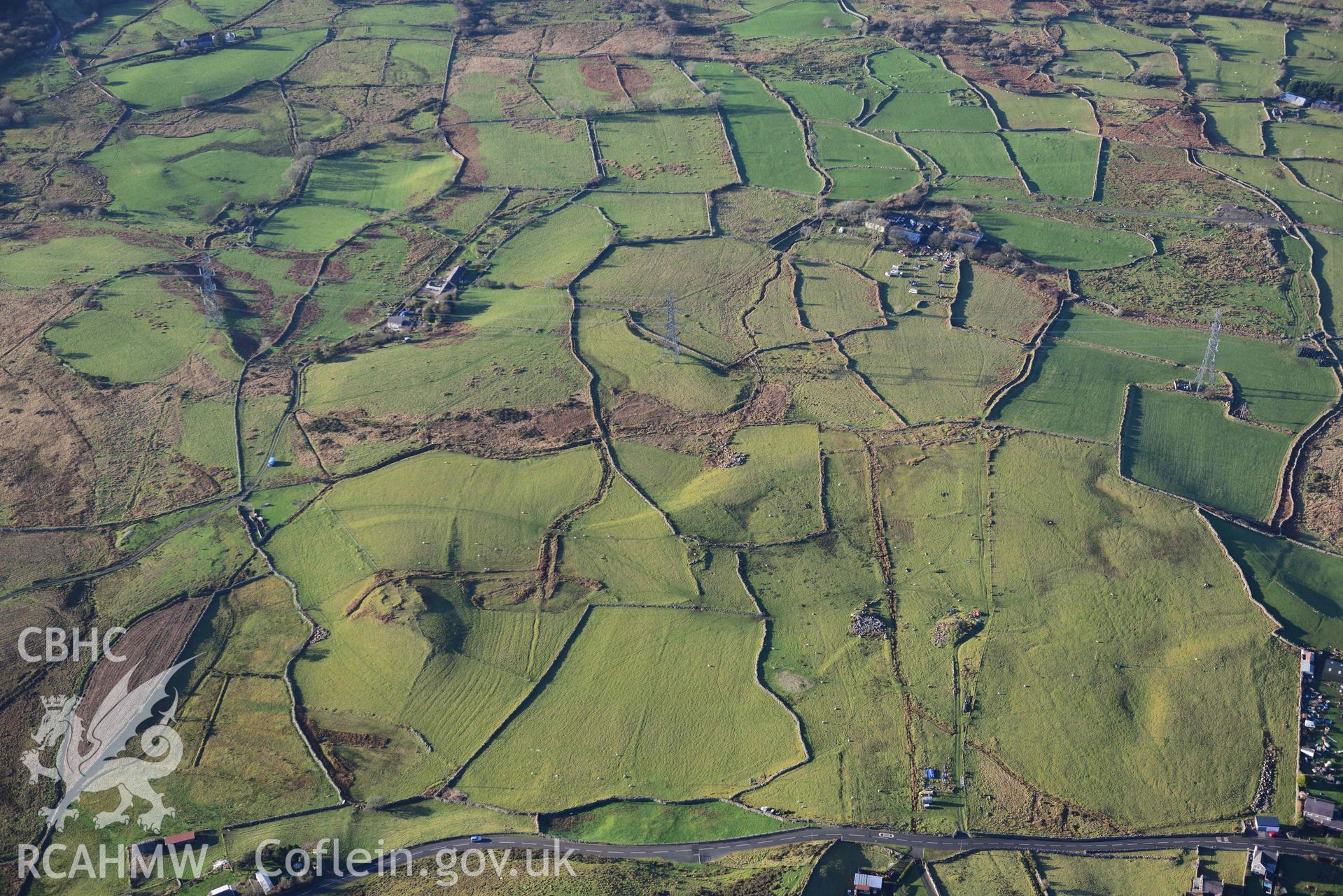 Oblique aerial photograph of Tan y Rhiw enclosed hut circle taken during the Royal Commission