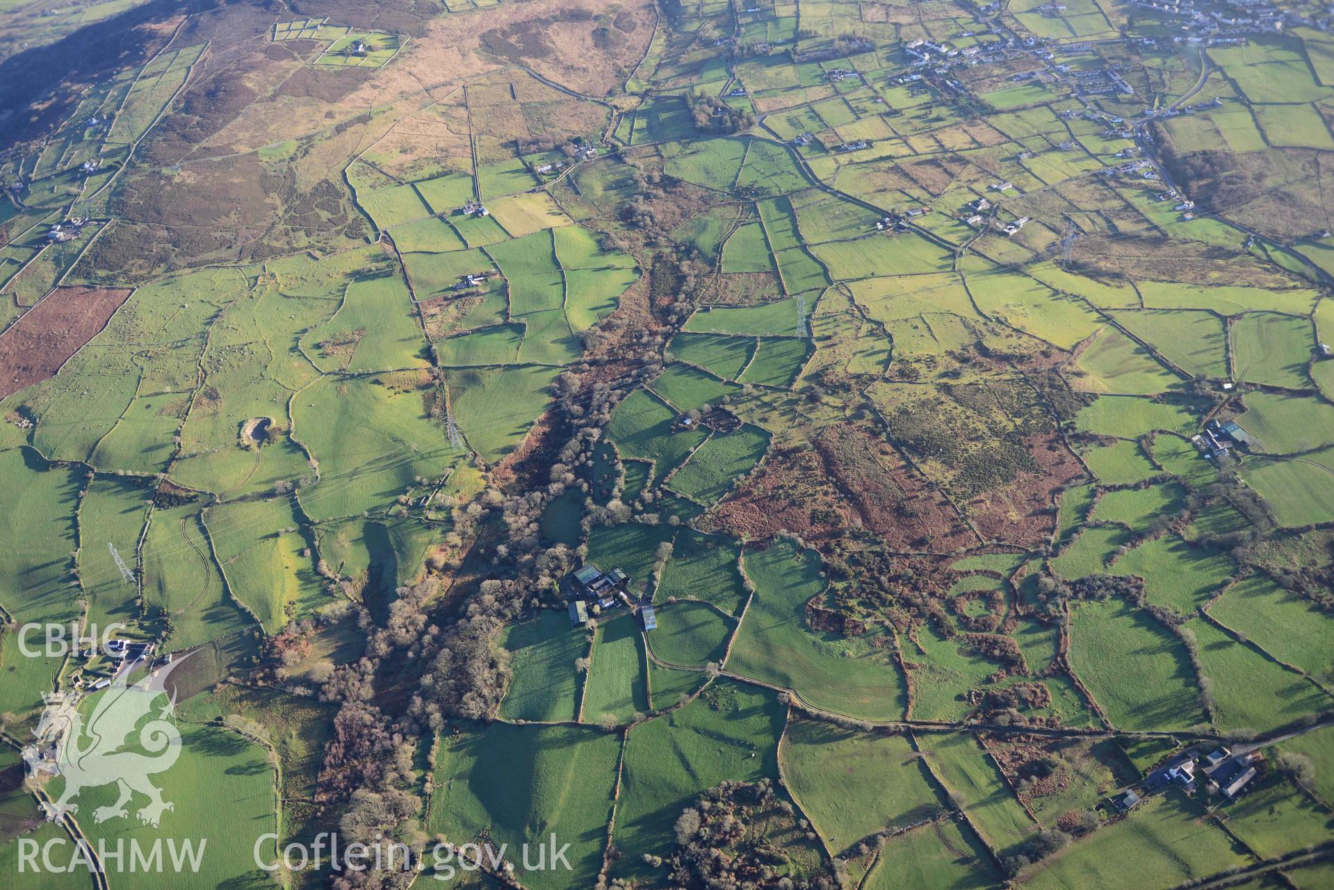 Oblique aerial photograph showing wide landscape view of Bod Angharad hut group, taken from the north west during the Royal Commission