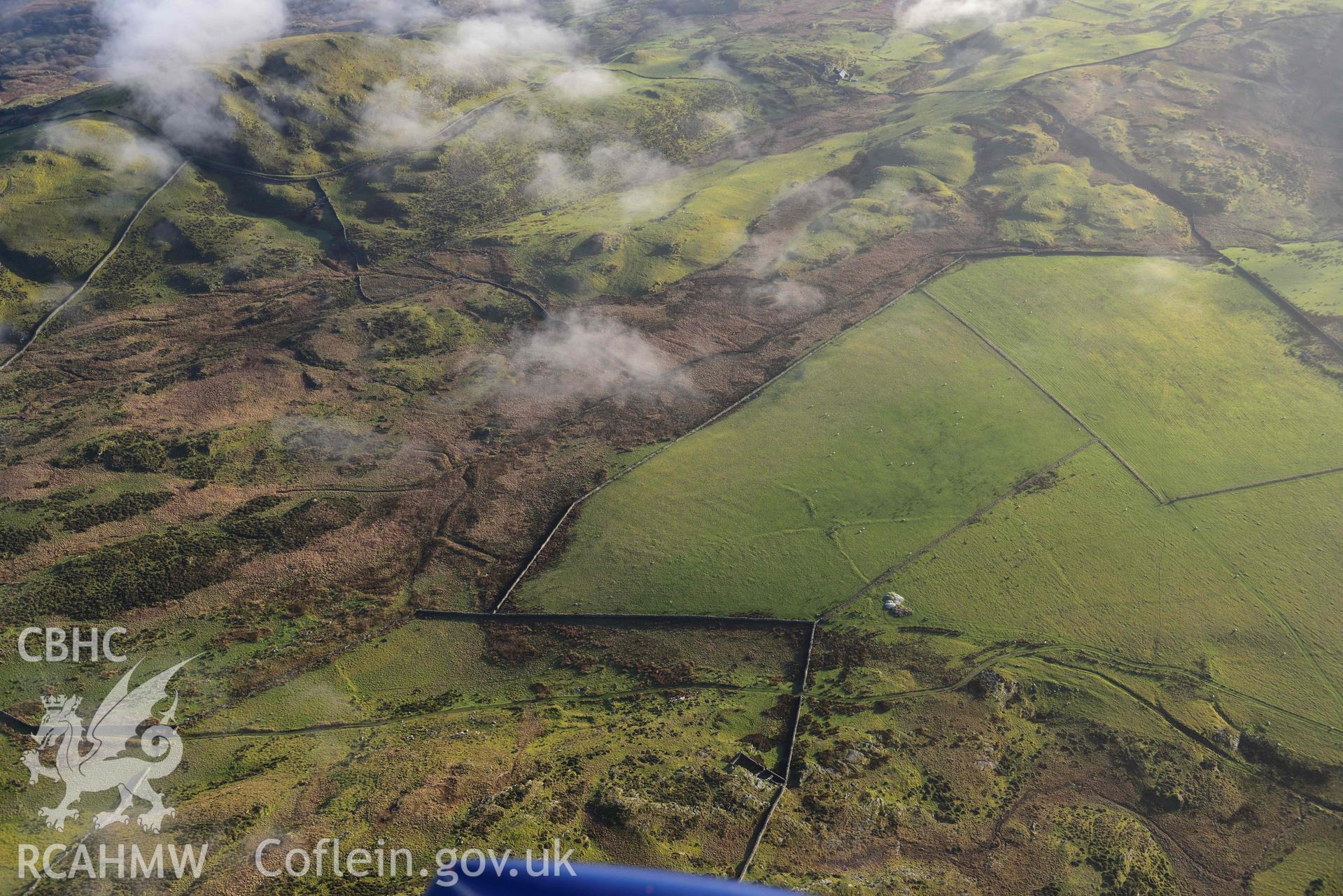 Oblique aerial photograph of Moel Goedog enclosed settlement, wide landscape view from North. Taken during the Royal Commission