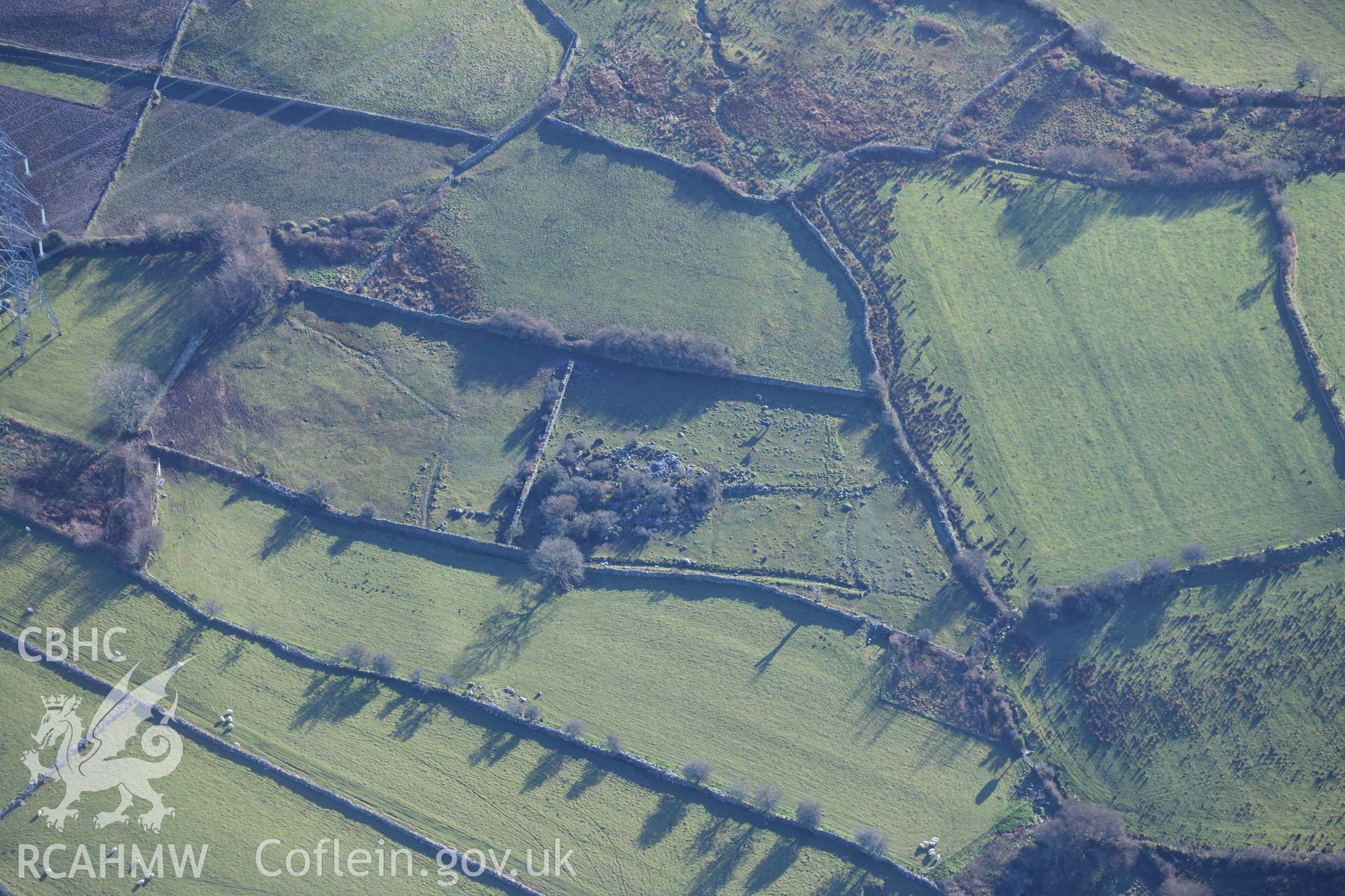 Oblique aerial photograph of Pen Llwyn hut group taken during the Royal Commission