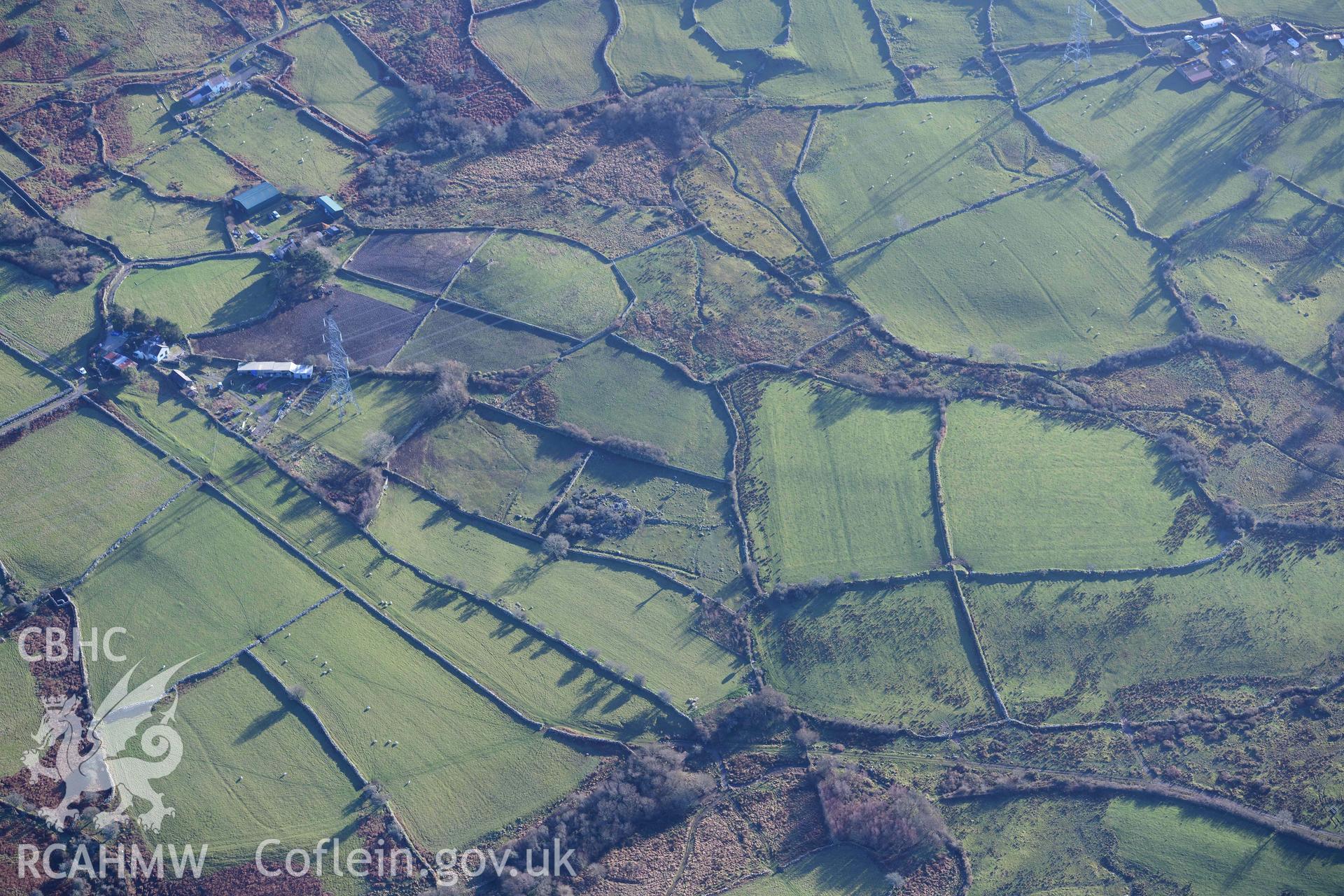 Oblique aerial photograph of Pen Llwyn hut group taken during the Royal Commission