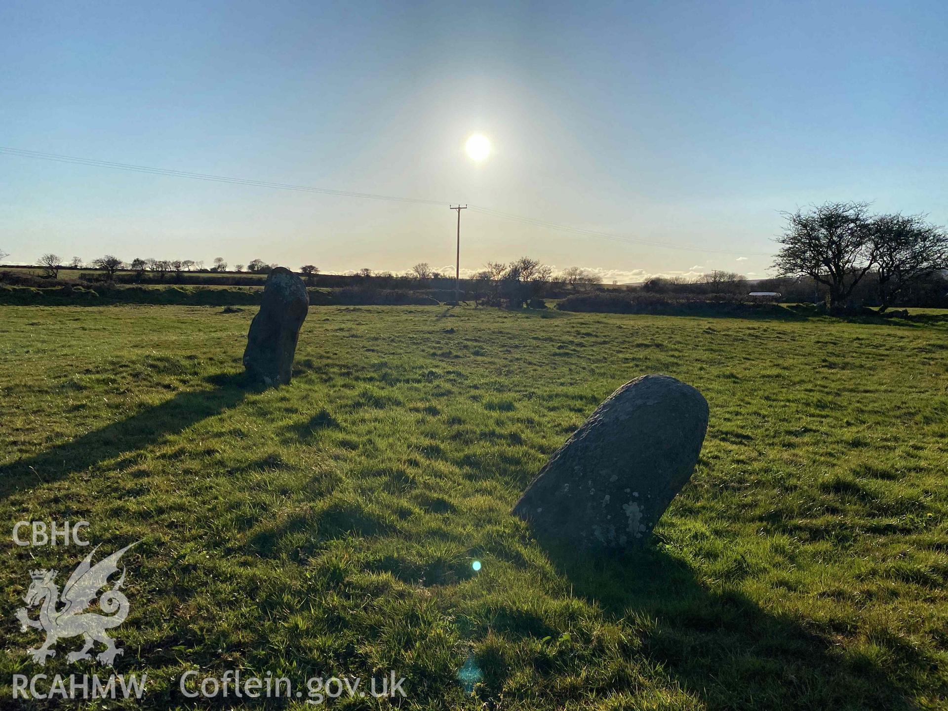 Digital photograph of the two surviving Meini Gwyr stones at Glandy Cross, facing the low sun, produced by Paul Davis in 2020