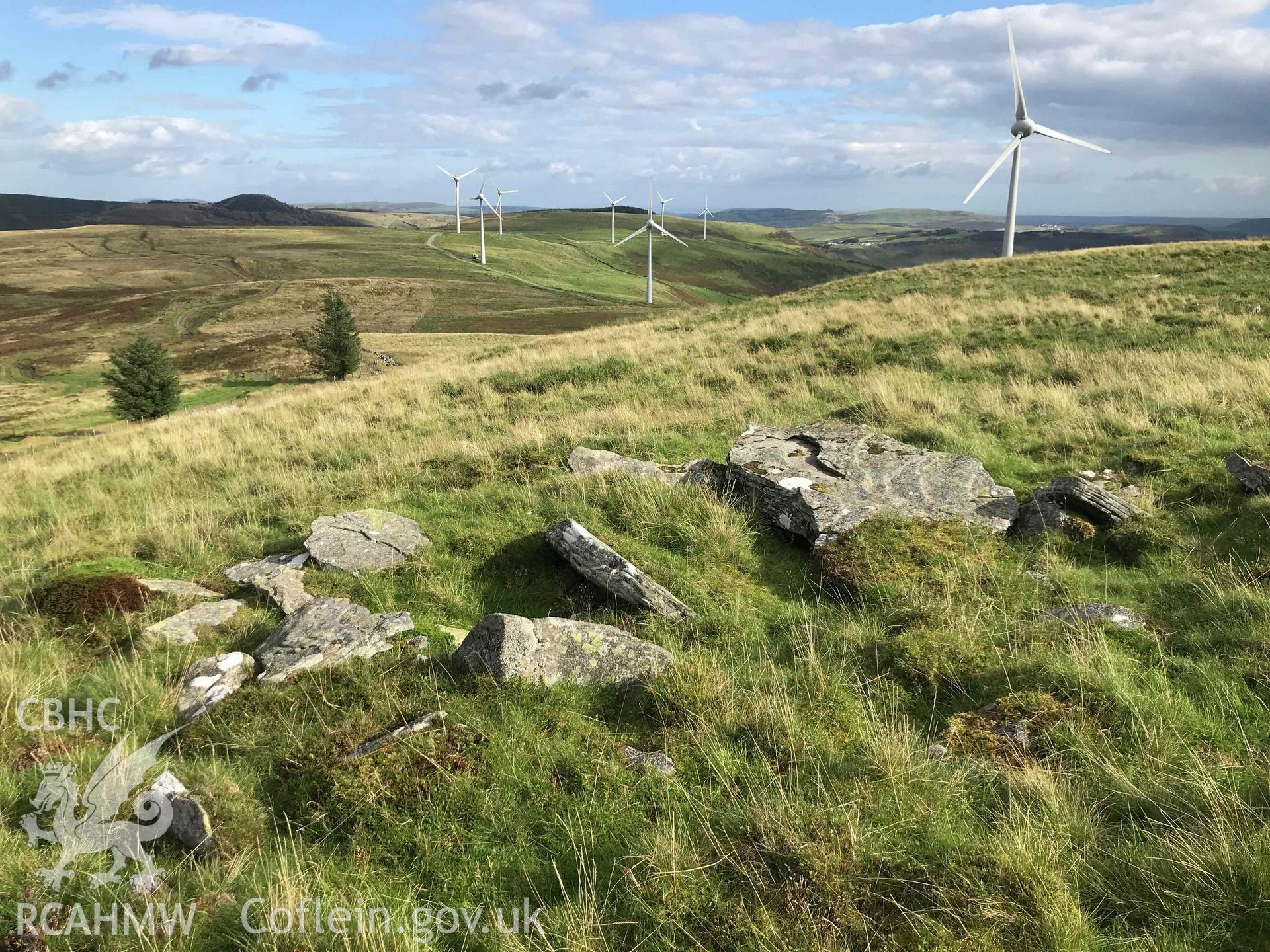 Digital photograph of  Tarren Maerdy cairn with windmills in background, produced by Paul Davis in 2020