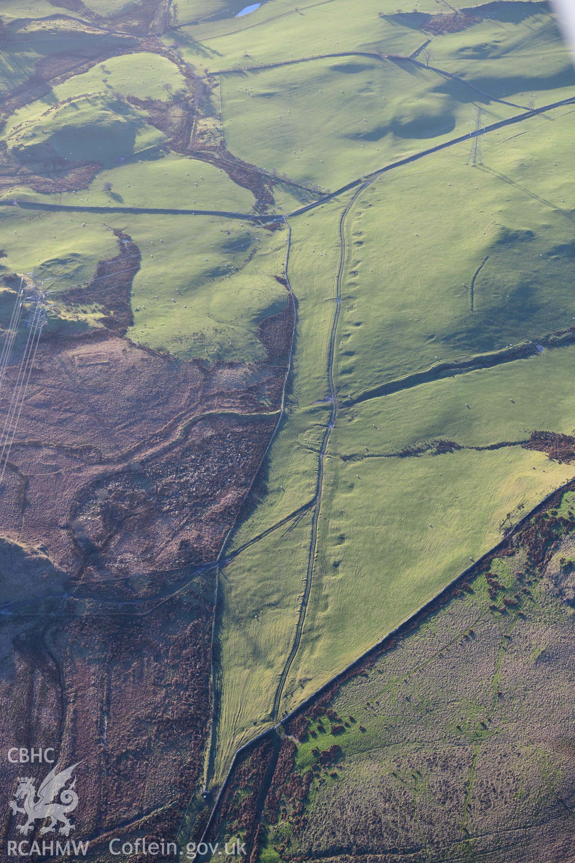 Oblique aerial photograph of Dolbelydr Roman road with quarry pits. Taken during the Royal Commission’s programme of archaeological aerial reconnaissance by Toby Driver on 17th January 2022