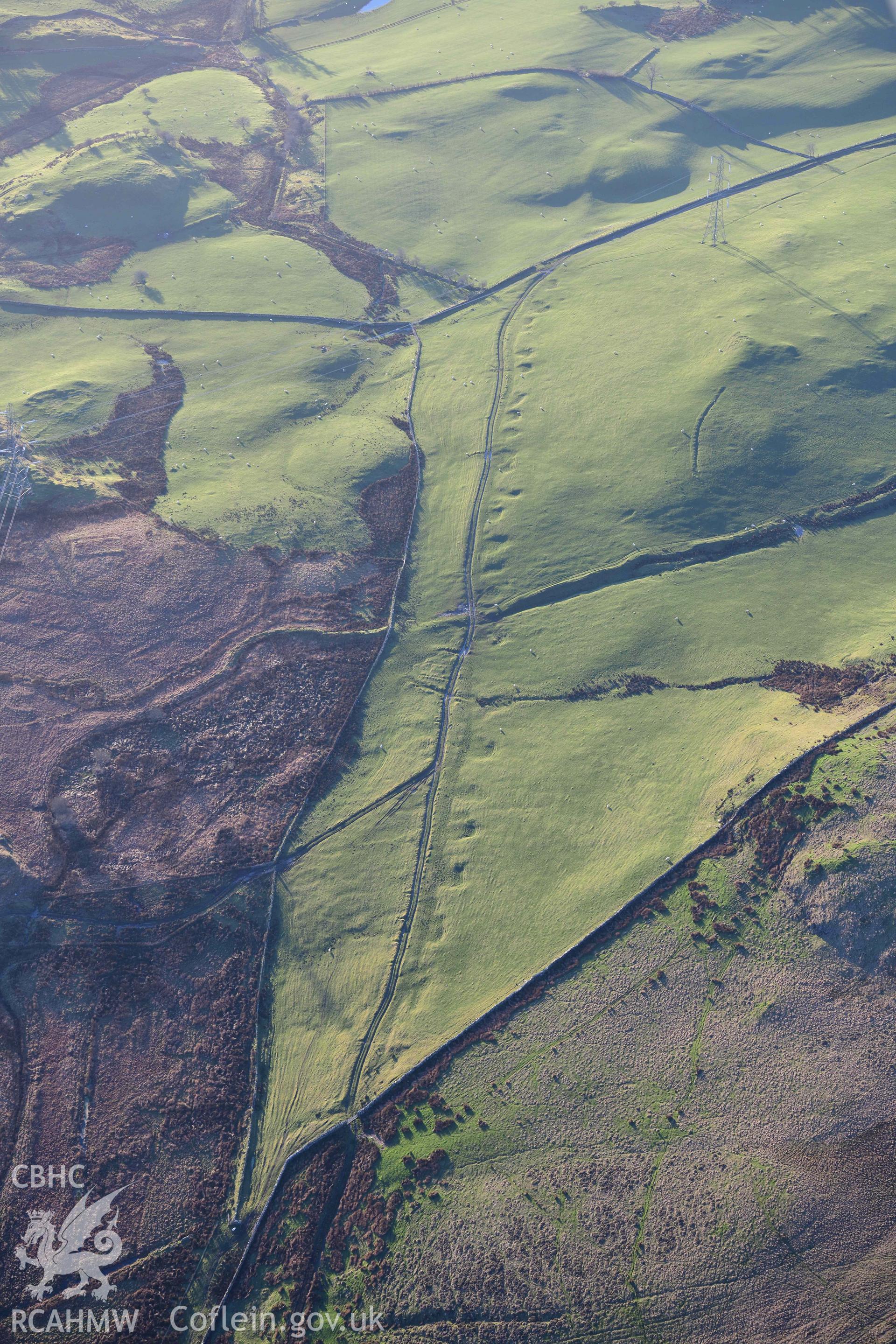 Oblique aerial photograph of Dolbelydr Roman road with quarry pits. Taken during the Royal Commission’s programme of archaeological aerial reconnaissance by Toby Driver on 17th January 2022