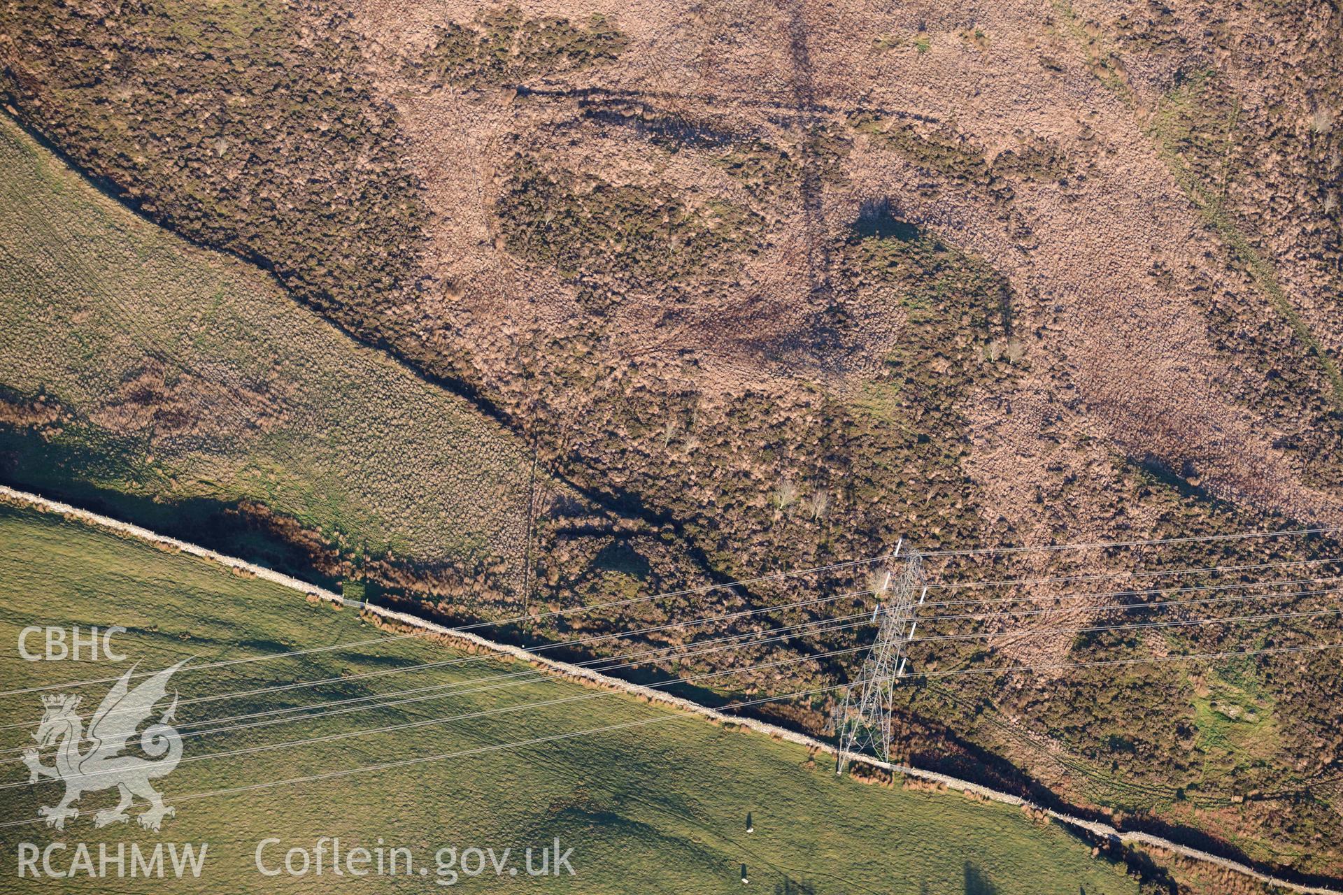 Oblique aerial photograph of Tomen y Mur square barrow to the south east of the fort. Taken during the Royal Commission’s programme of archaeological aerial reconnaissance by Toby Driver on 17th January 2022