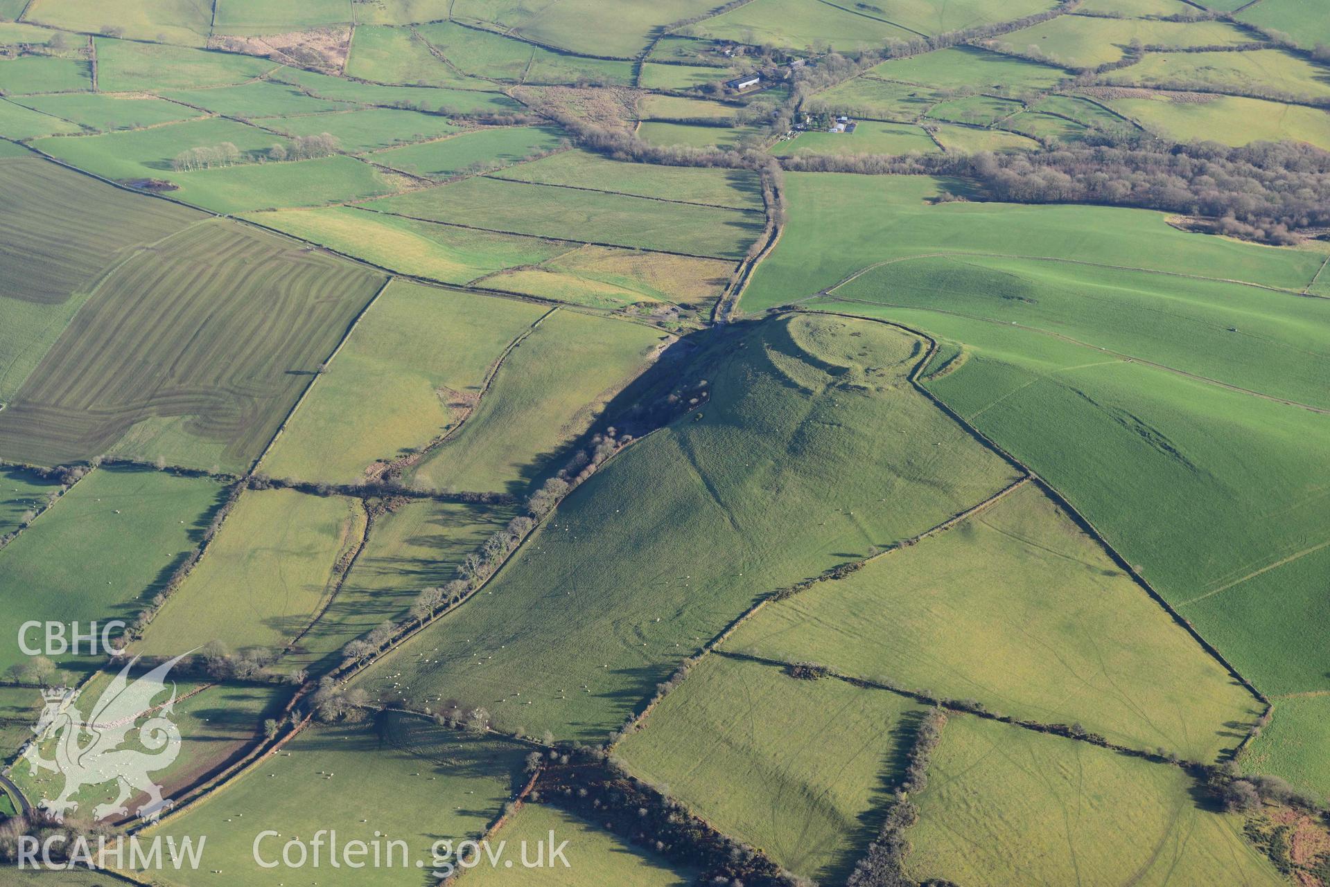 Oblique aerial photograph of Castell Perthi Mawr, with earthworks of prehistoric fields to the north west. Taken during the Royal Commission’s programme of archaeological aerial reconnaissance by Toby Driver on 17th January 2022