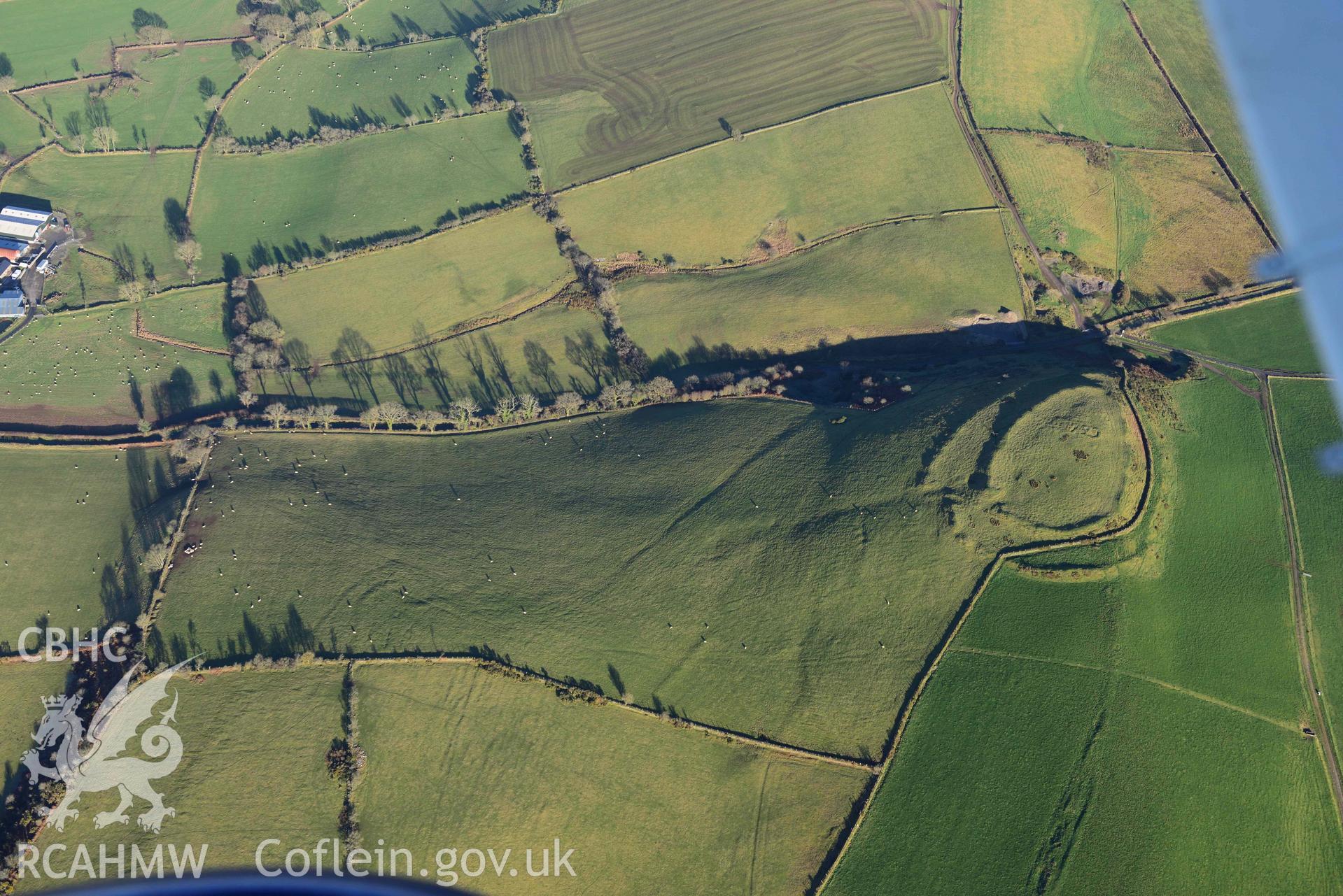 Oblique aerial photograph of Castell Perthi Mawr, with earthworks of prehistoric fields to the north west. Taken during the Royal Commission’s programme of archaeological aerial reconnaissance by Toby Driver on 17th January 2022